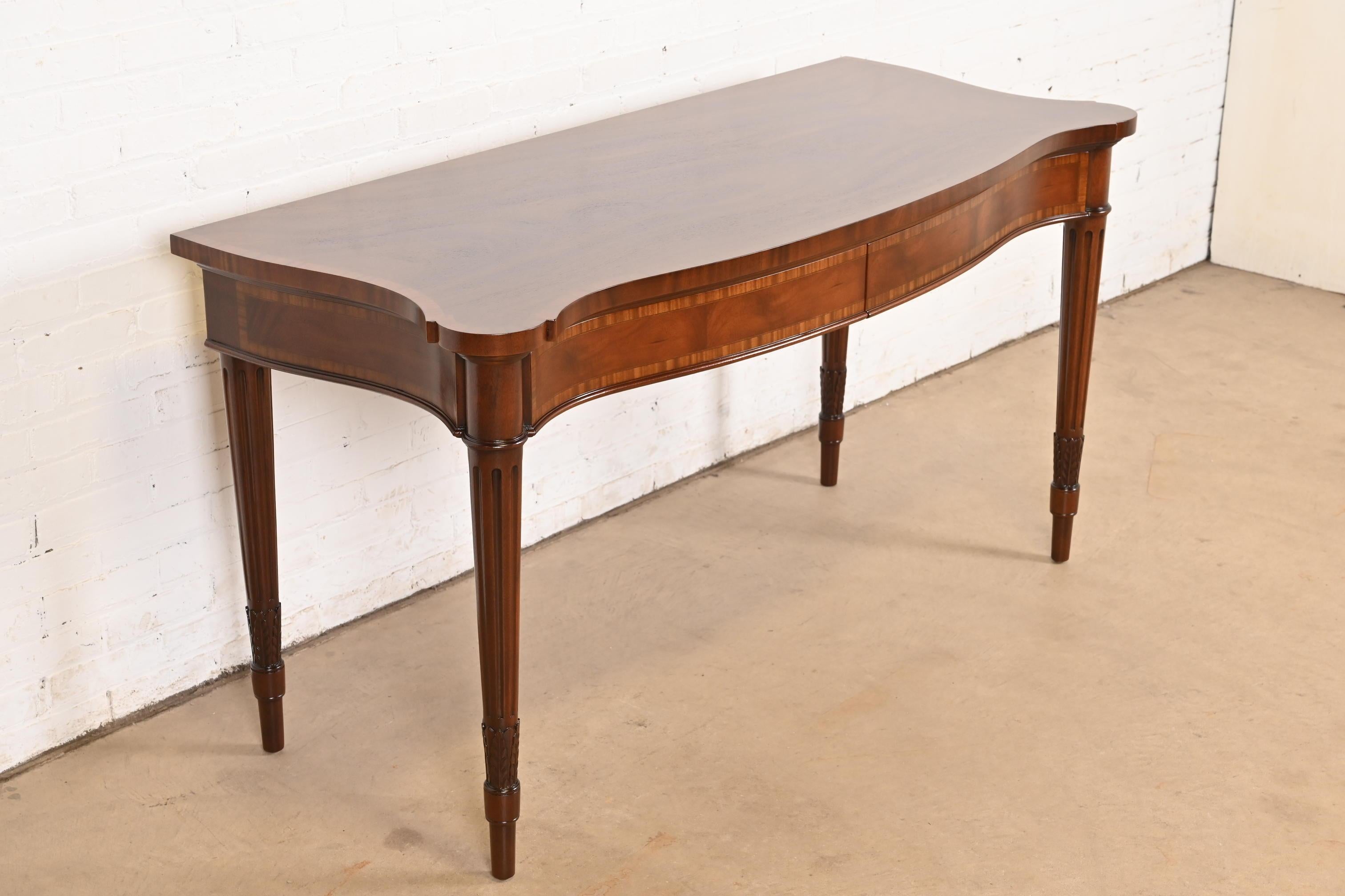 Un'eccezionale credenza inglese Regency in stile Luigi XVI con fronte a serpentina, un buffet o un tavolo da console

Da Arthur Brett & Sons

Inghilterra, circa anni '80

Splendido mogano intagliato, con bordatura in legno satinato.

Misure: 62,5