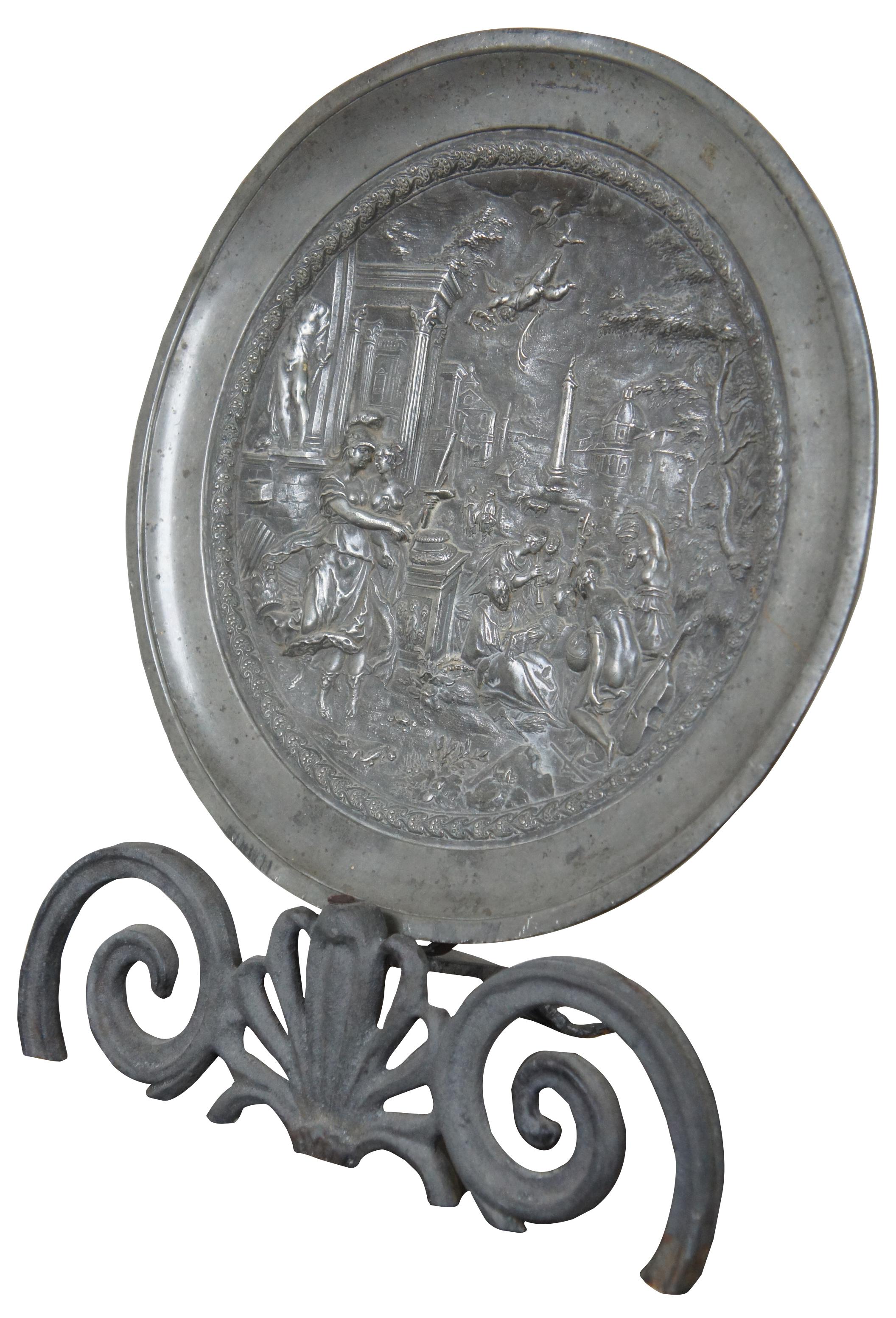 Pewter plate by Arthur Chaumette (Paris, France), circa 1890s. Featuring a detailed Renaissance scene of a Roman forum with Cupid flying above Athena and other figures. Stamped on reverse with a crowned rose with the initials “ND” and another worn