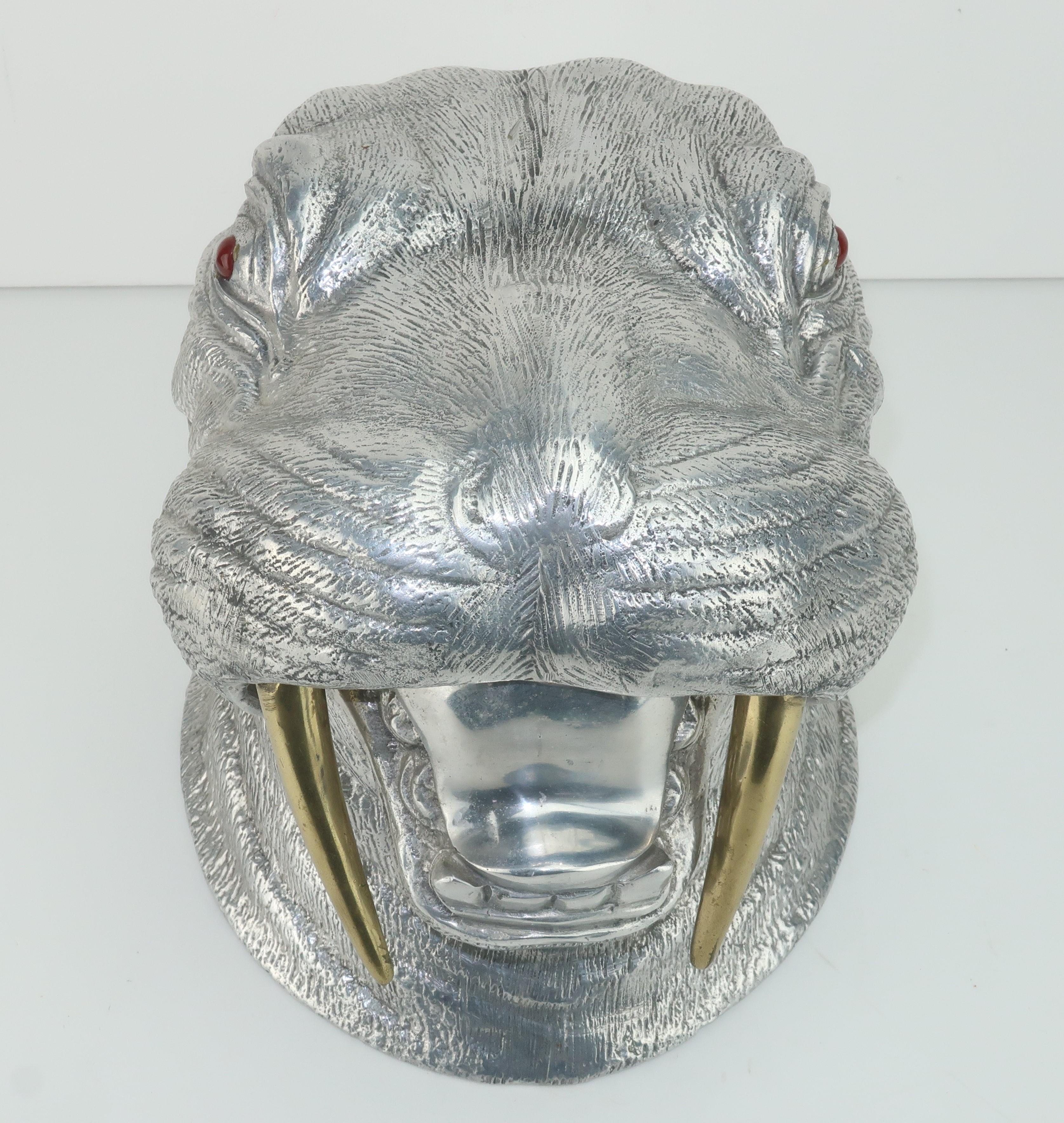 A whimsical Arthur Court walrus shaped wine cooler or ice bucket in cast aluminum with brass tusks and carnelian eyes. This sea faring gentleman is loaded with personality and has design details that provide a realistic appearance while serving as a