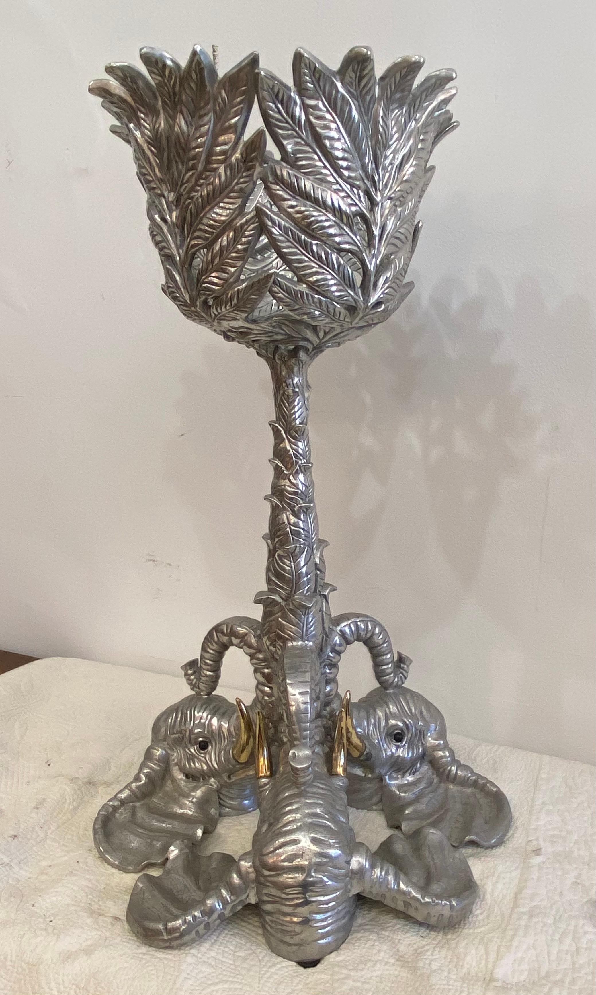 Free standing wine cooler stand made by Arthur Court. Three cast aluminum elephants with brass tusks supporting a floral stem. Tropical leaves surround at top.