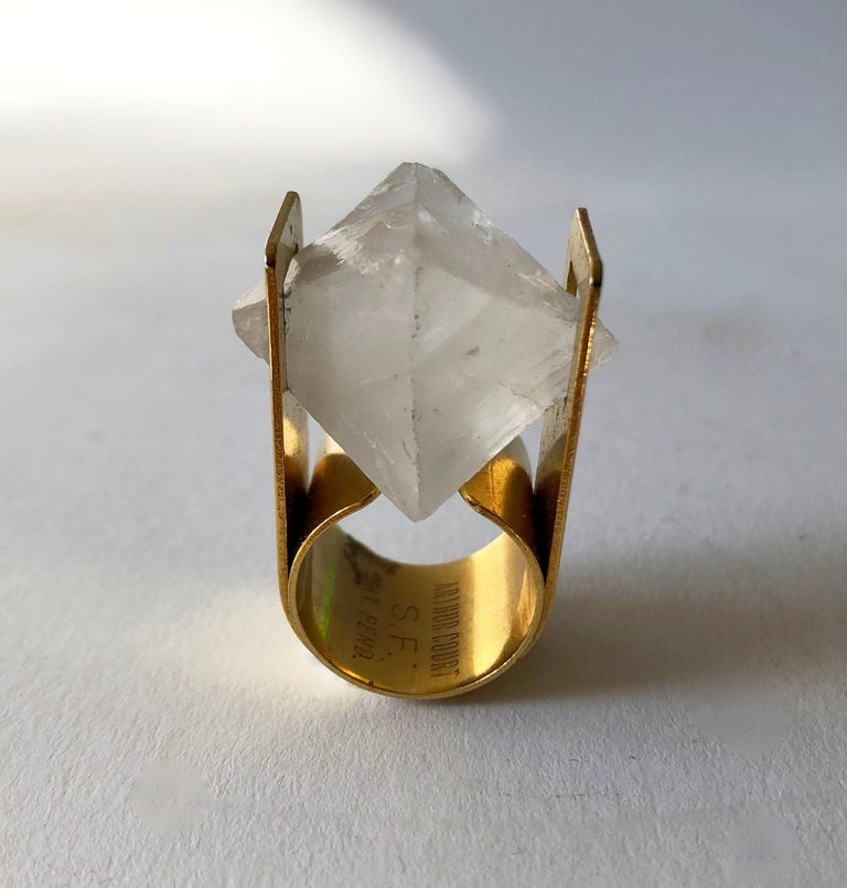 A large, over the top statement ring by Arthur Court of San Francisco, California.  Ring features a tension set large chunk of cut quartz in an electroplated brass shank.  A finger size 6 and signed Arthur Court, SF.  In very good vintage condition.