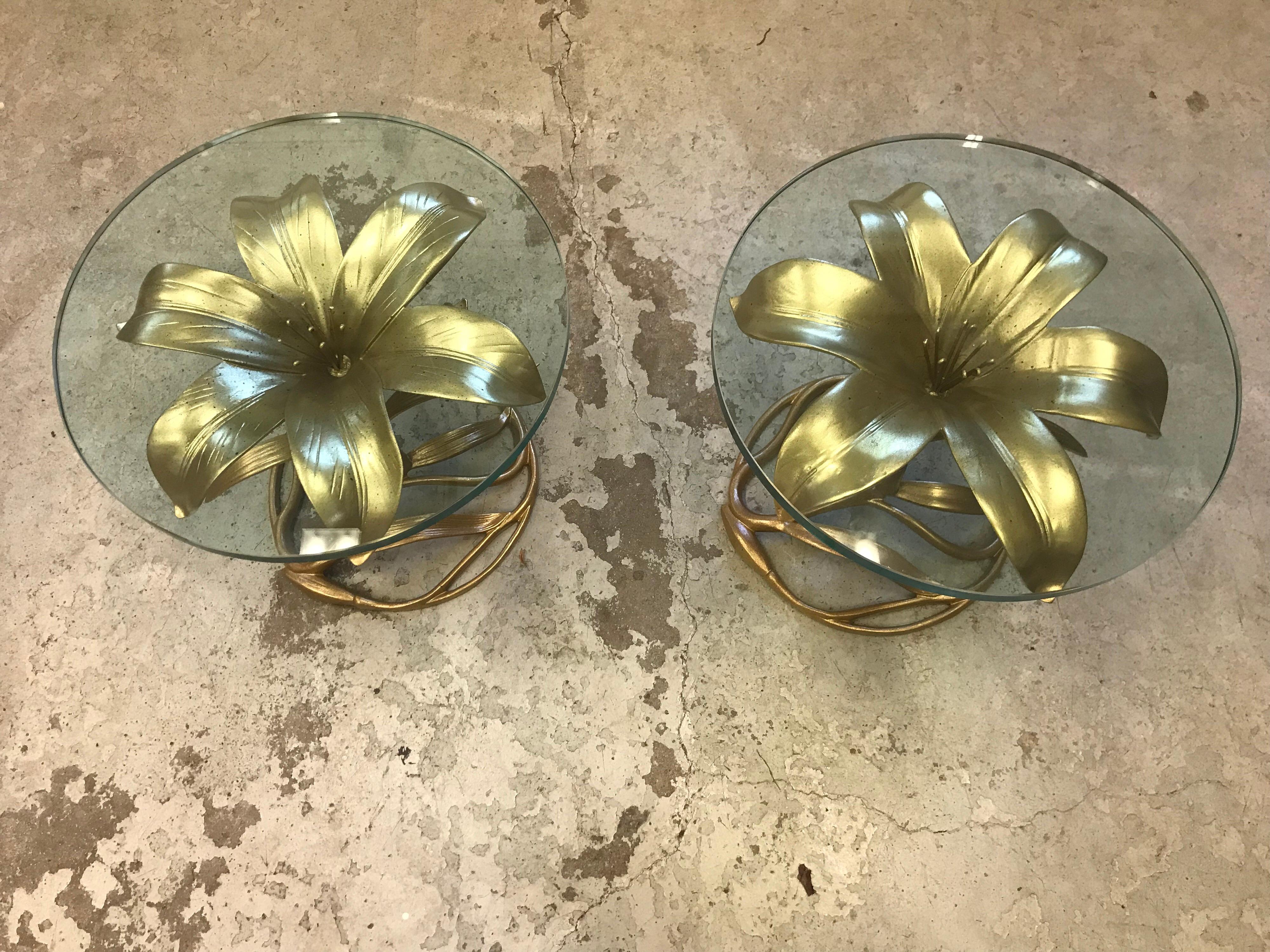 This is a pair of aluminum gilded calalily tables with glass round tops made by Arthur Court.