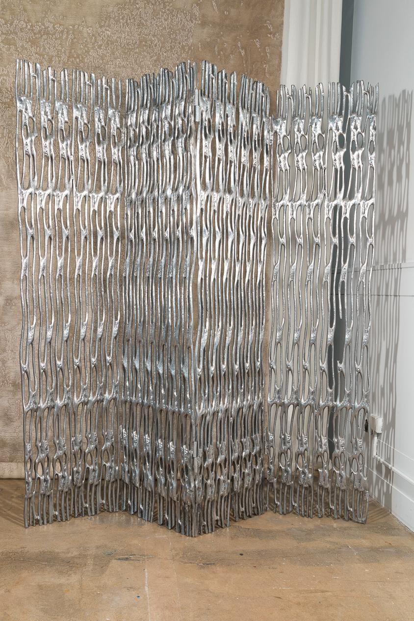 This is a rare Arthur Court polished aluminum screen. It has six panels and was made in the late 1950s. The screen is finished and polished on both sides. All panels can be folded or extended. There's two small pieces that are broken. We do have the