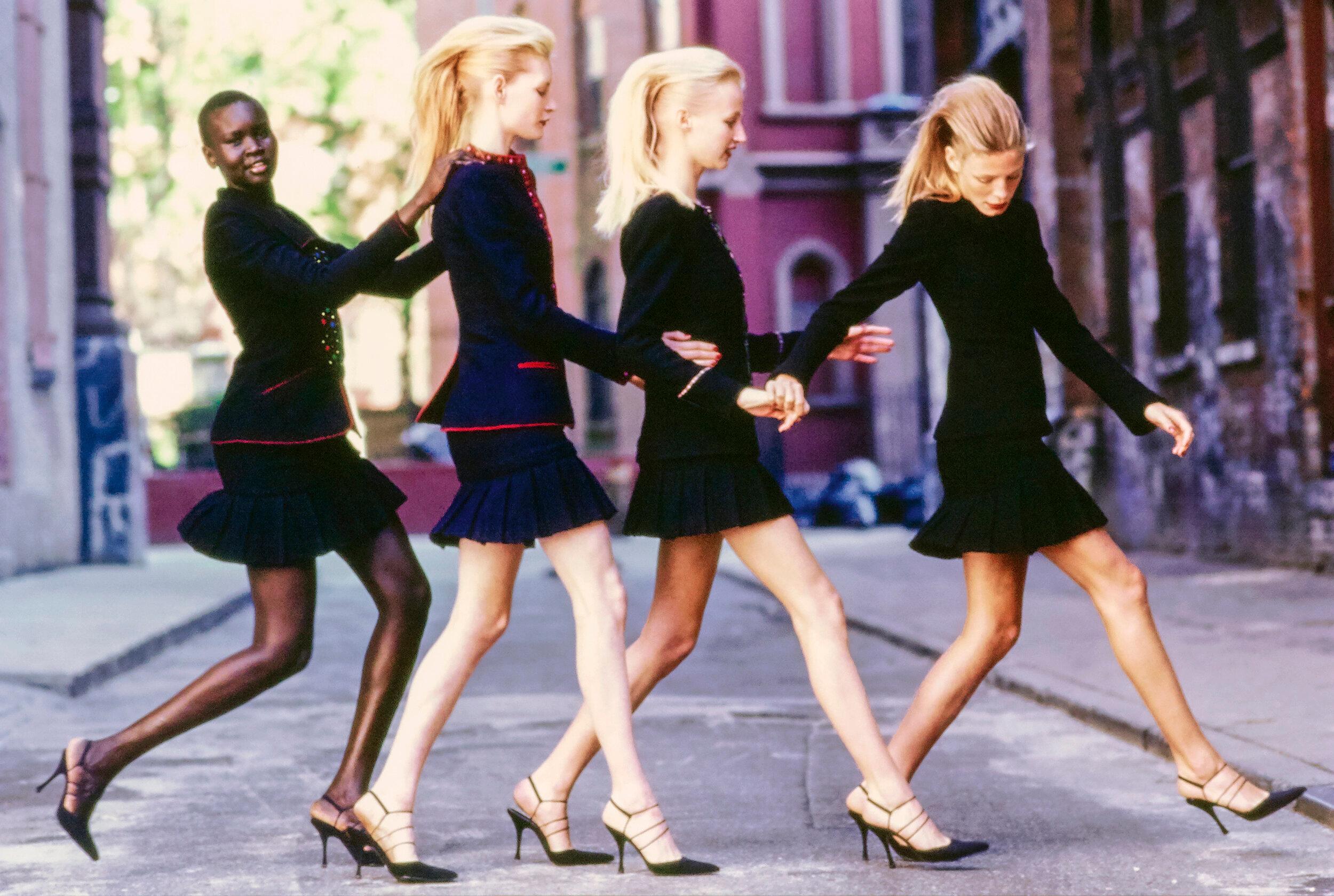 Arthur Elgort Color Photograph - Alek Wek for Vogue - four models in black powersuits, fine art photography, 1997