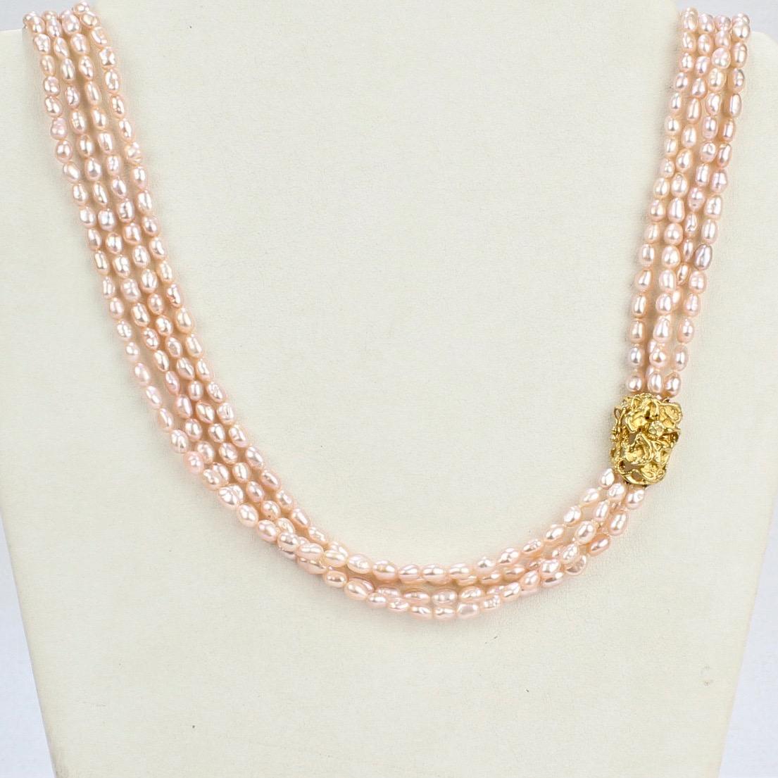 A beautifully designed Arthur King necklace in 18 karat gold and fresh water pearls.

The four strand necklace is strung with fresh water pearls with a slight pink to white hue and set with an 18K gold Brutalist clasp. 

With a great length that