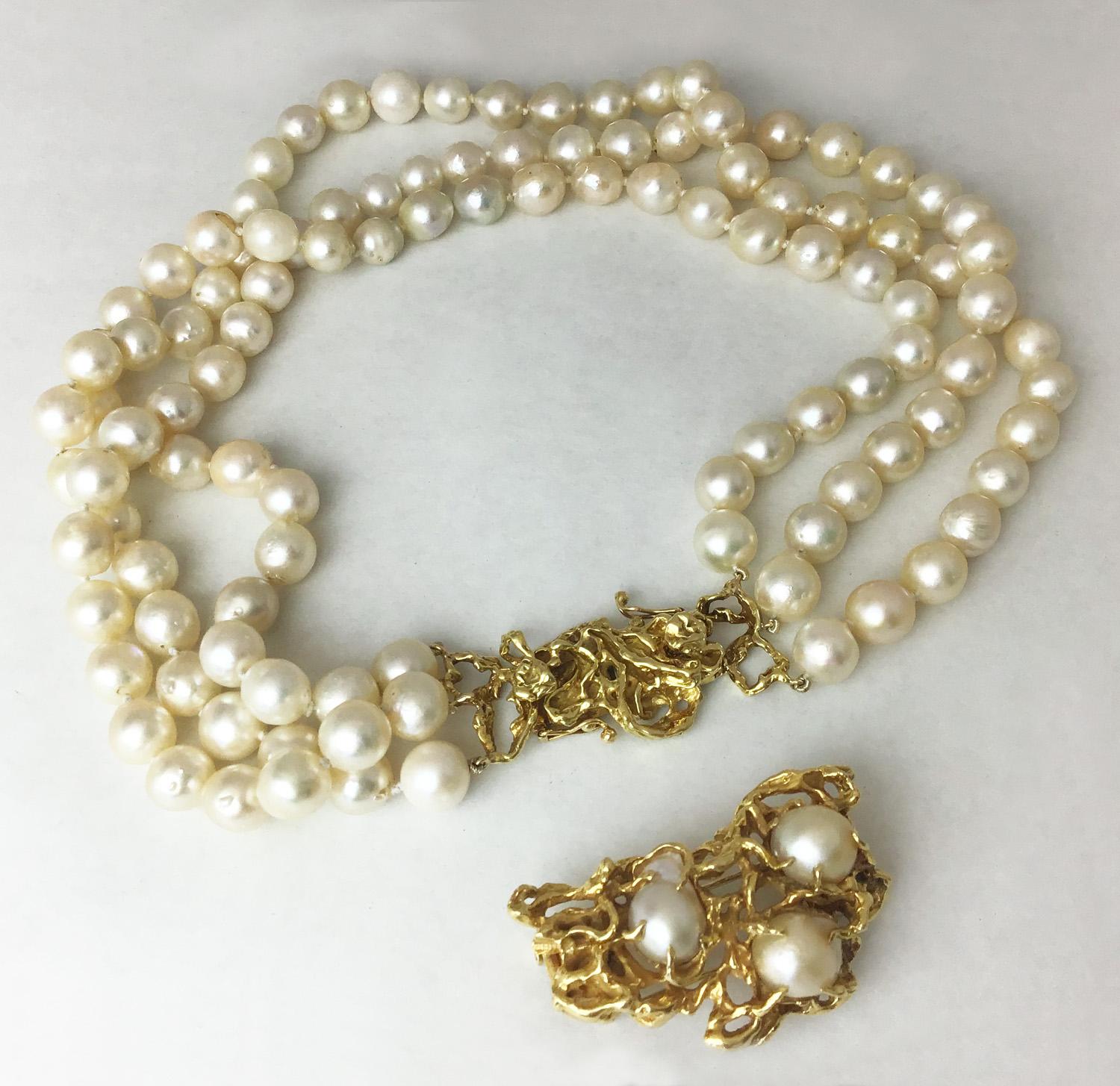 A fabulous three strand pearl necklace set with convertible clasp and brooch in 18K gold made by famous jeweler Arthur King. 

Necklace has two interchangeable clasps. The larger pearl clasp makes it an impressive statement piece, smaller one
