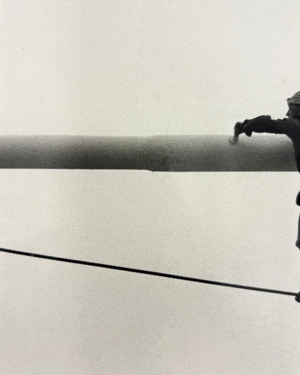 Malerbalken (S/W-Fotografie aus den 1950er Jahren von einem an einem Draht hängenden Mann) im Angebot 1