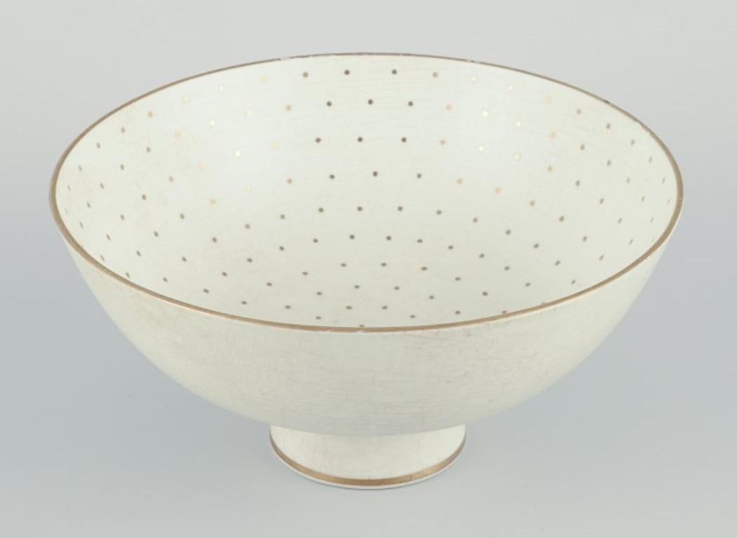 Arthur Percy pour Gefle, Suède. Bol en porcelaine sur socle.
Décoration dorée avec des points.
Marqué.
Vers les années 1940.
Modèle 2039.
En bon état, plusieurs petits éclats au sommet.
Dimensions : Diamètre 19,0 cm. x Hauteur 9,5 cm.