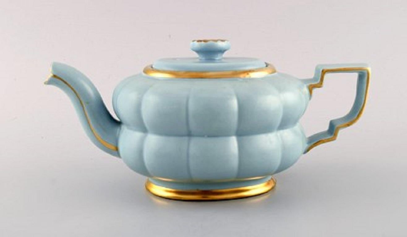 Arthur Percy for Upsala-Ekeby / Gefle. Complete Art Deco Grand tea service in pastel blue porcelain with hand painted gold edge, 1930s-1940s.
Consisting of five teacups with saucers, five plates, sugar / cream set and teapot.
The cup measures: 11