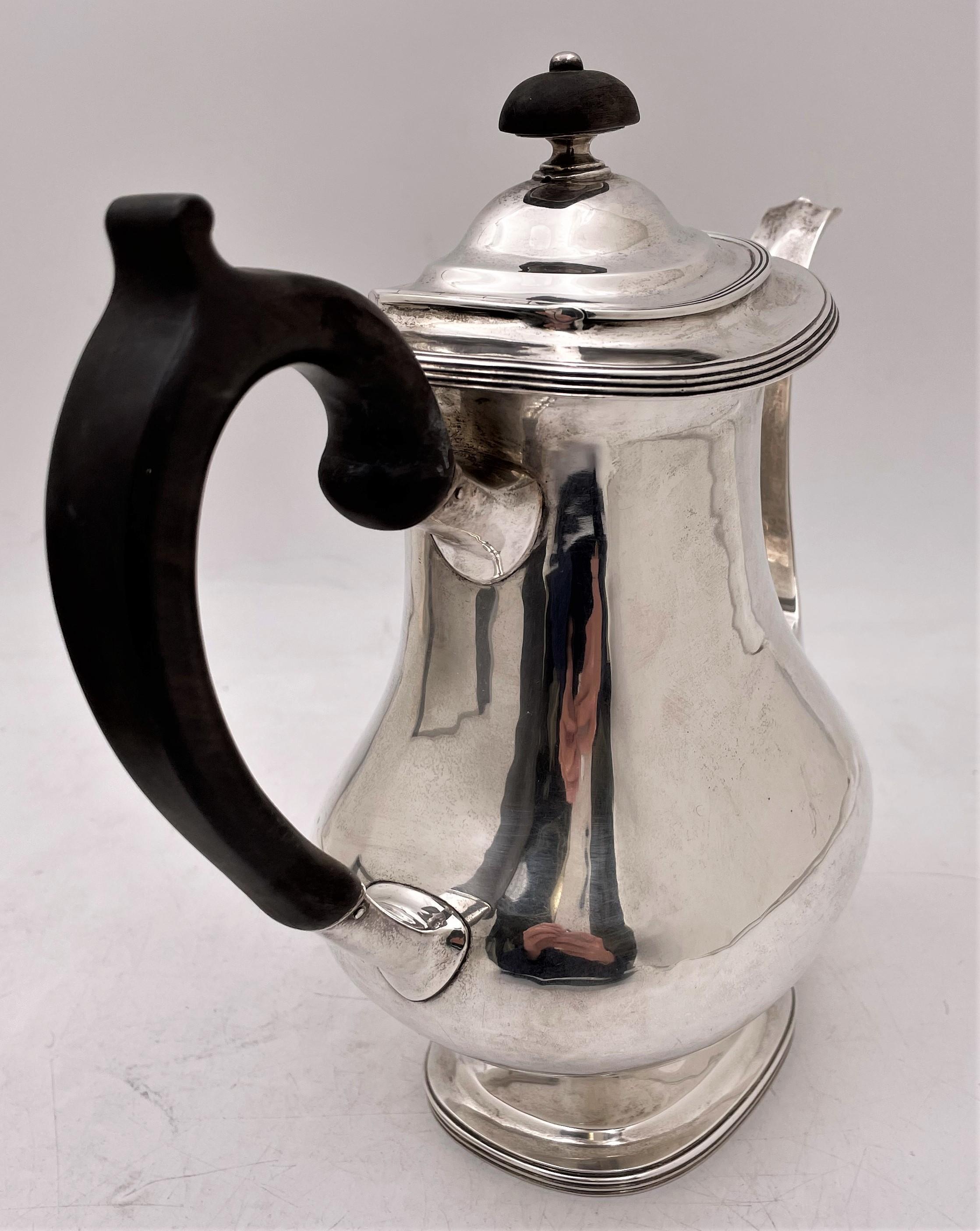 Arthur Stone, hand hammered sterling silver coffee pot in Arts & Crafts style with a dark wood handle and finial. This extremely elegant pot exhibits the attention to geometric, curvilinear design typical of the Arts & Crafts movement. It measures 8