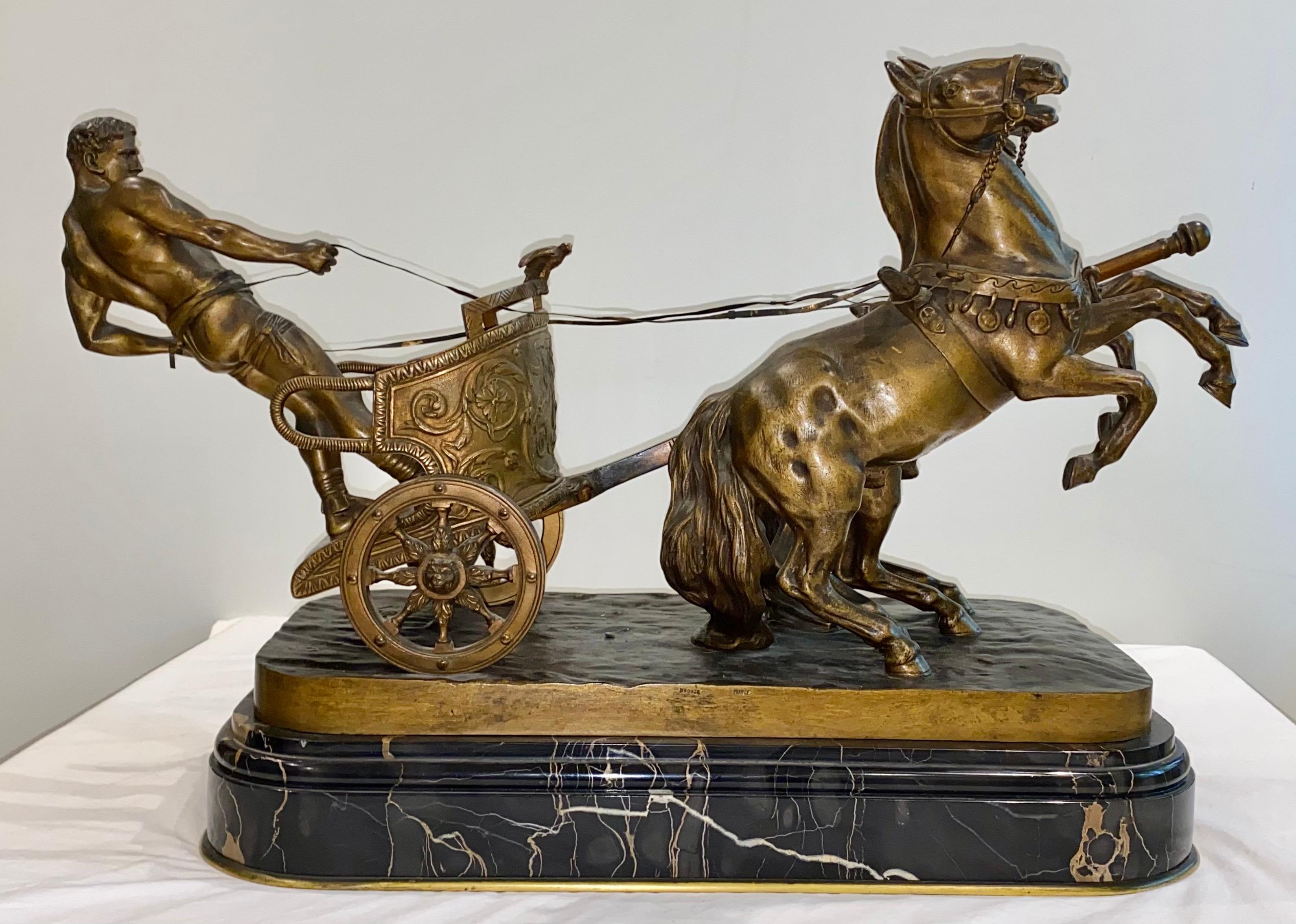 Arthur Strasser (1854-1927, Austrian) bronze group of a Roman Charioteer. The powerful scene has two horses rearing back, the man is standing at the back of the chariot holding the reins; the chariot has nice detail including scrolling leaf work on