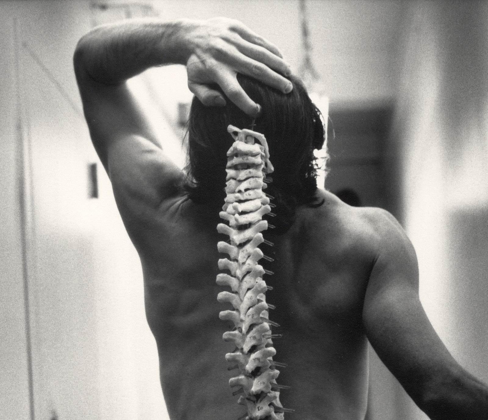 Spinal Tap (nude male standing with skeleton of actual spinal column) - Photograph by Arthur Tress