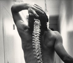 Spinal Tap (nude male standing with skeleton of actual spinal column)