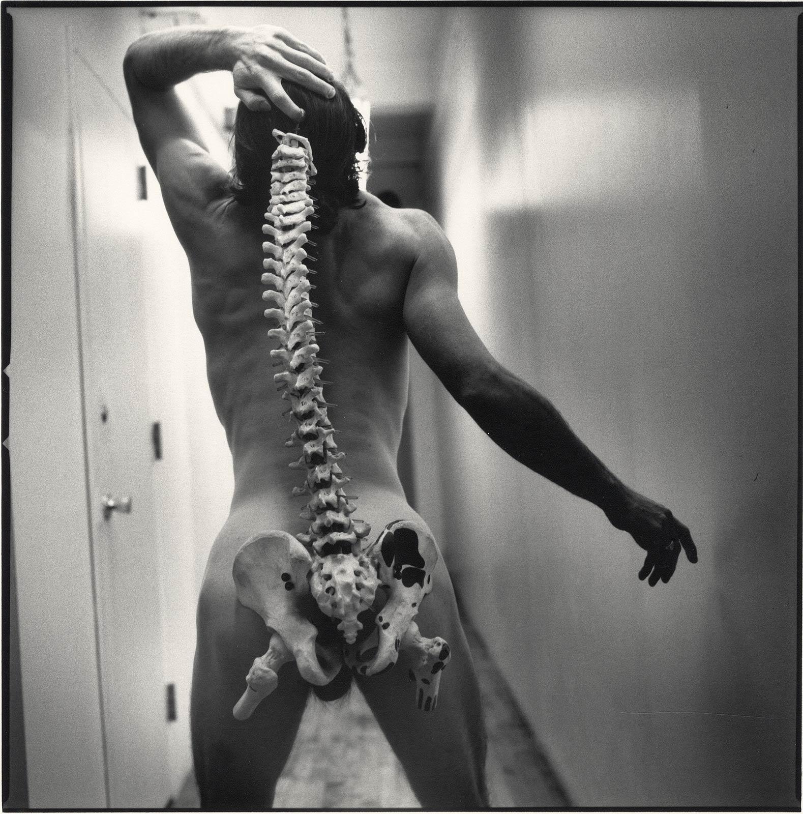 Arthur Tress Nude Photograph - Spinal Tap (nude male standing with skeleton of actual spinal column)