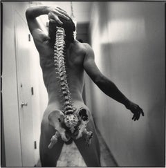 Spinal Tap (nude male standing with skeleton of actual spinal column)