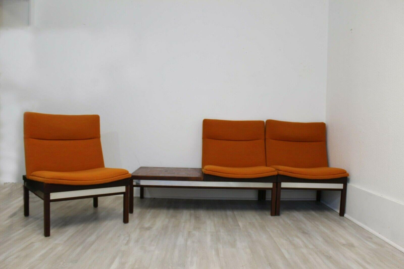 This bench seating is a fantastic example of Arthur Umanoff iconic design and includes a walnut, parquet side table attached to an upholstered orange seat. The set also includes two, separate and matching orange upholstered chairs making this a