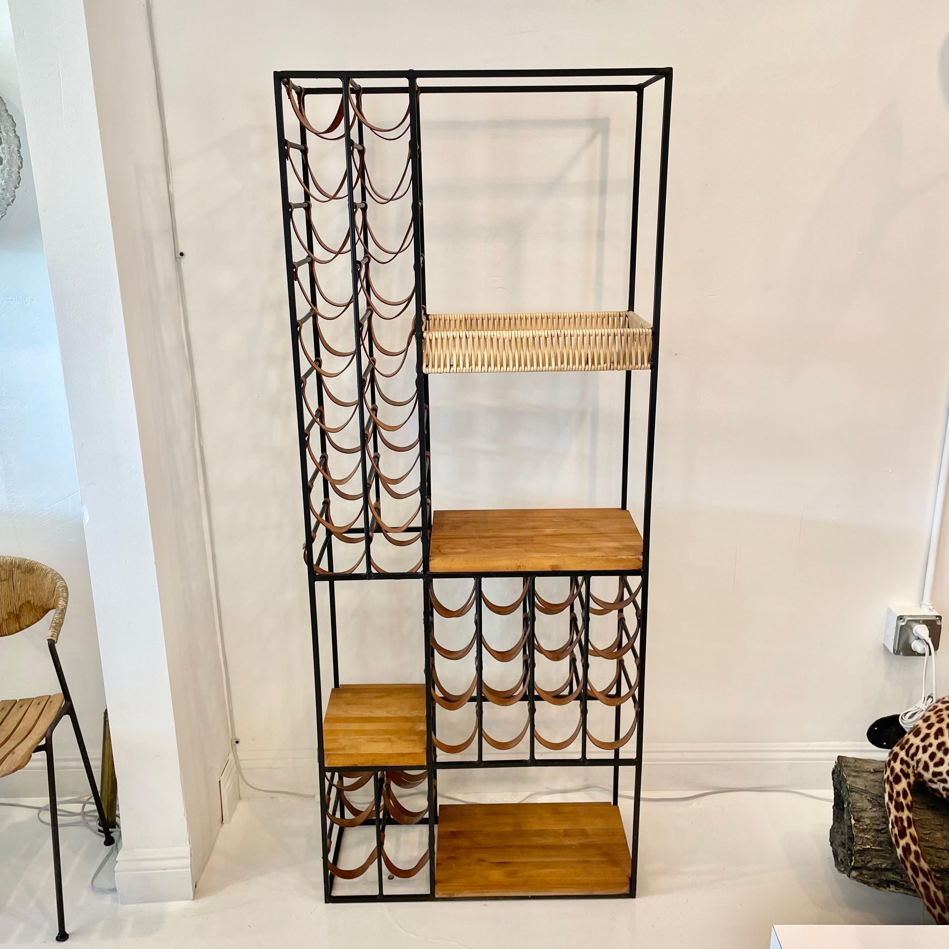 Fantastic Arthur Umanoff wine rack in iron, leather and wood block. Holds 40 bottles in the leather slings held in place by iron bars and metal grommets. Four additional wood shelves for objects, books or more bottles. Stunning condition with
