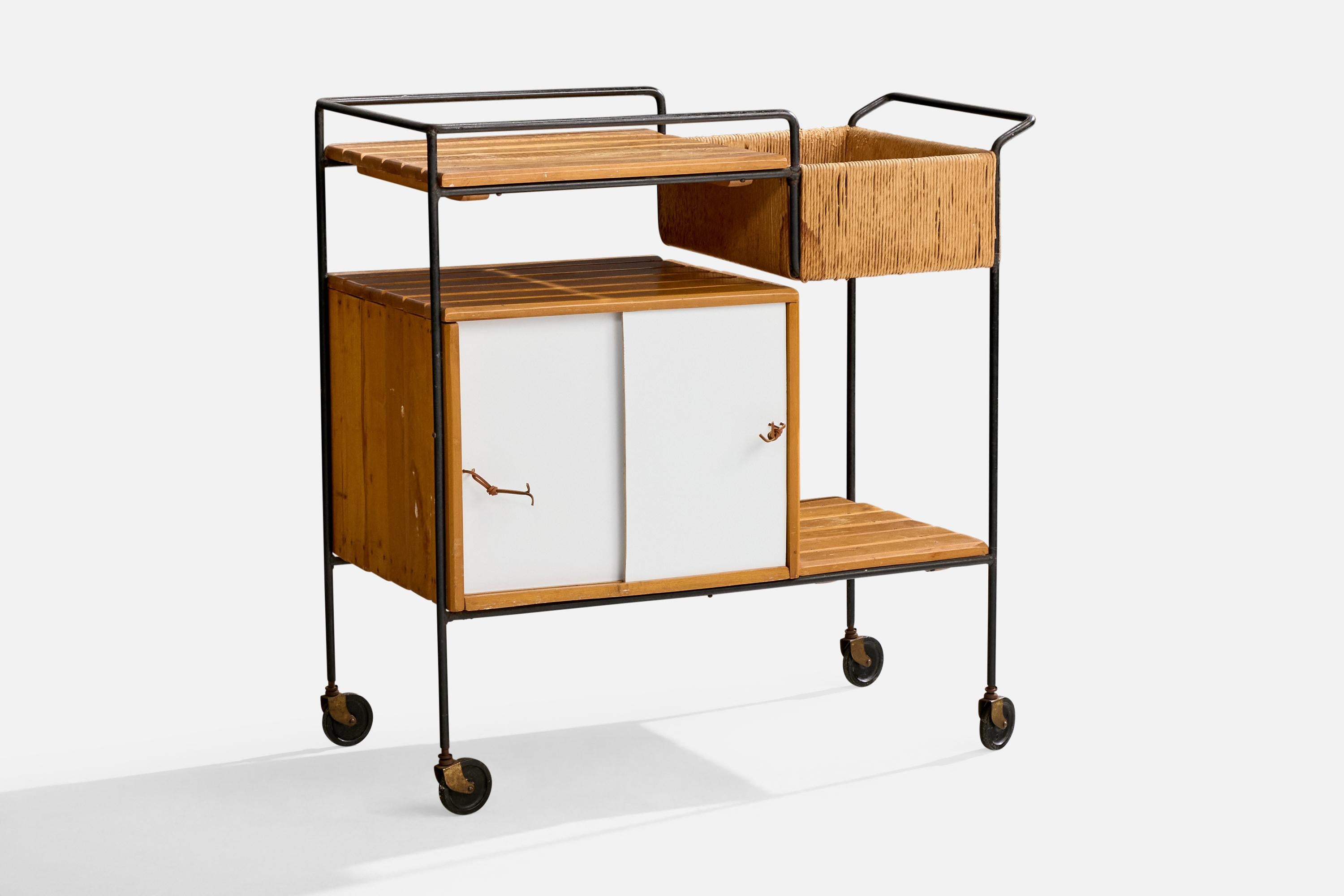 A black-lacquered iron, birch, rush and white formica bar cart designed by Arthur Umanoff and produced by Raymor, USA, c. 1950s.

Light to moderate discoloration present throughout wood.

Overall Dimensions (inches): 36.25