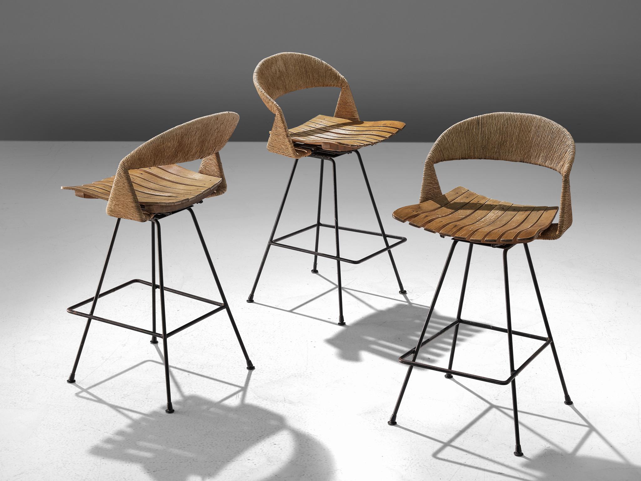 Arthur Umanoff for Raymore, set three bar stools, iron, cane and plywood, United States, 1950s

A set of three barstools by Arthur Umanoff for Raymor. The stools consist of an iron base with a squared frame for the sitter to rest their feet. The