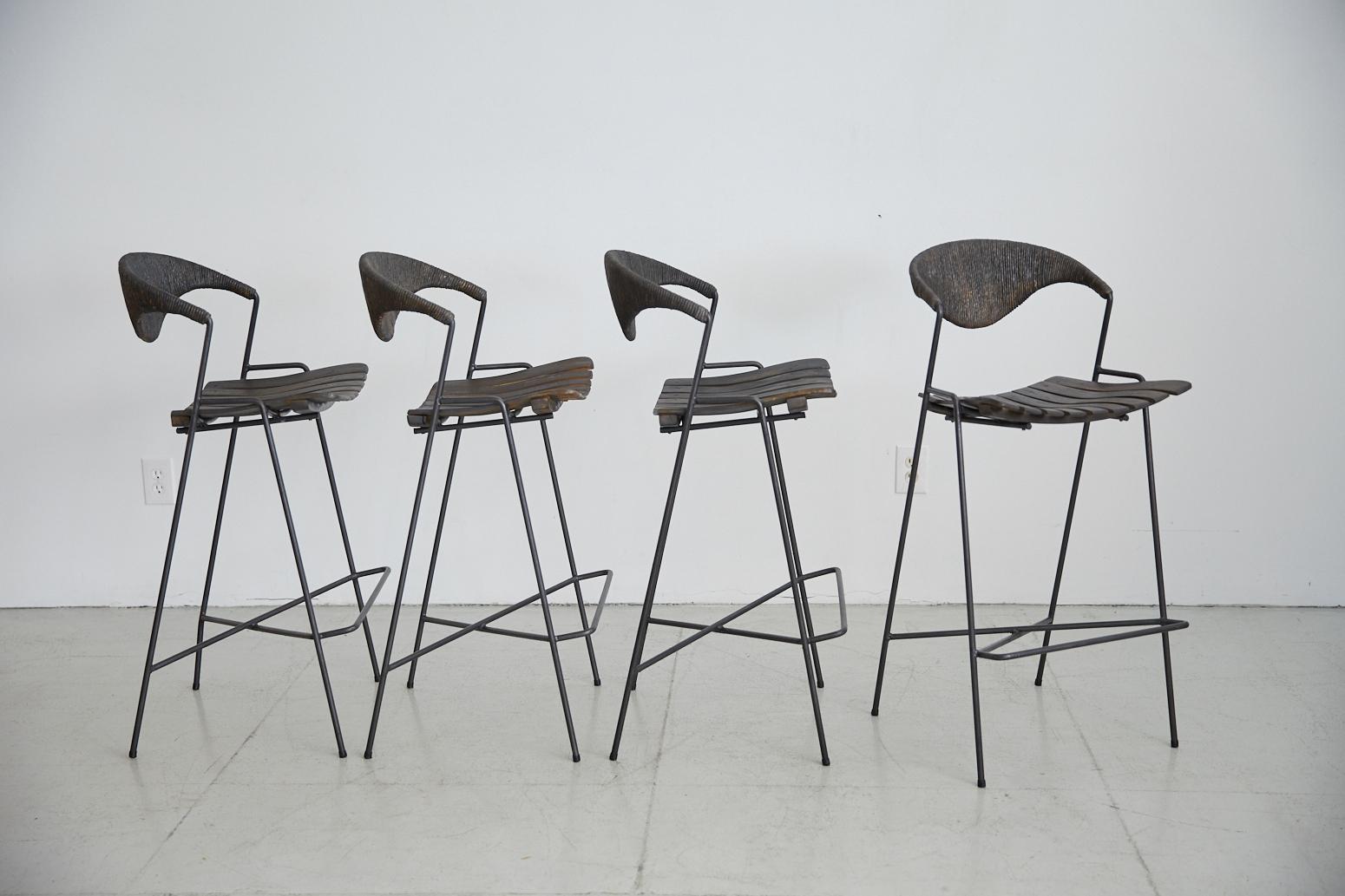 Great set of four barstools by Arthur Umanoff for Raymor. Black iron frame with black paper cord backs and dark ebony wood slatted seats. Priced and sold individually.
          
