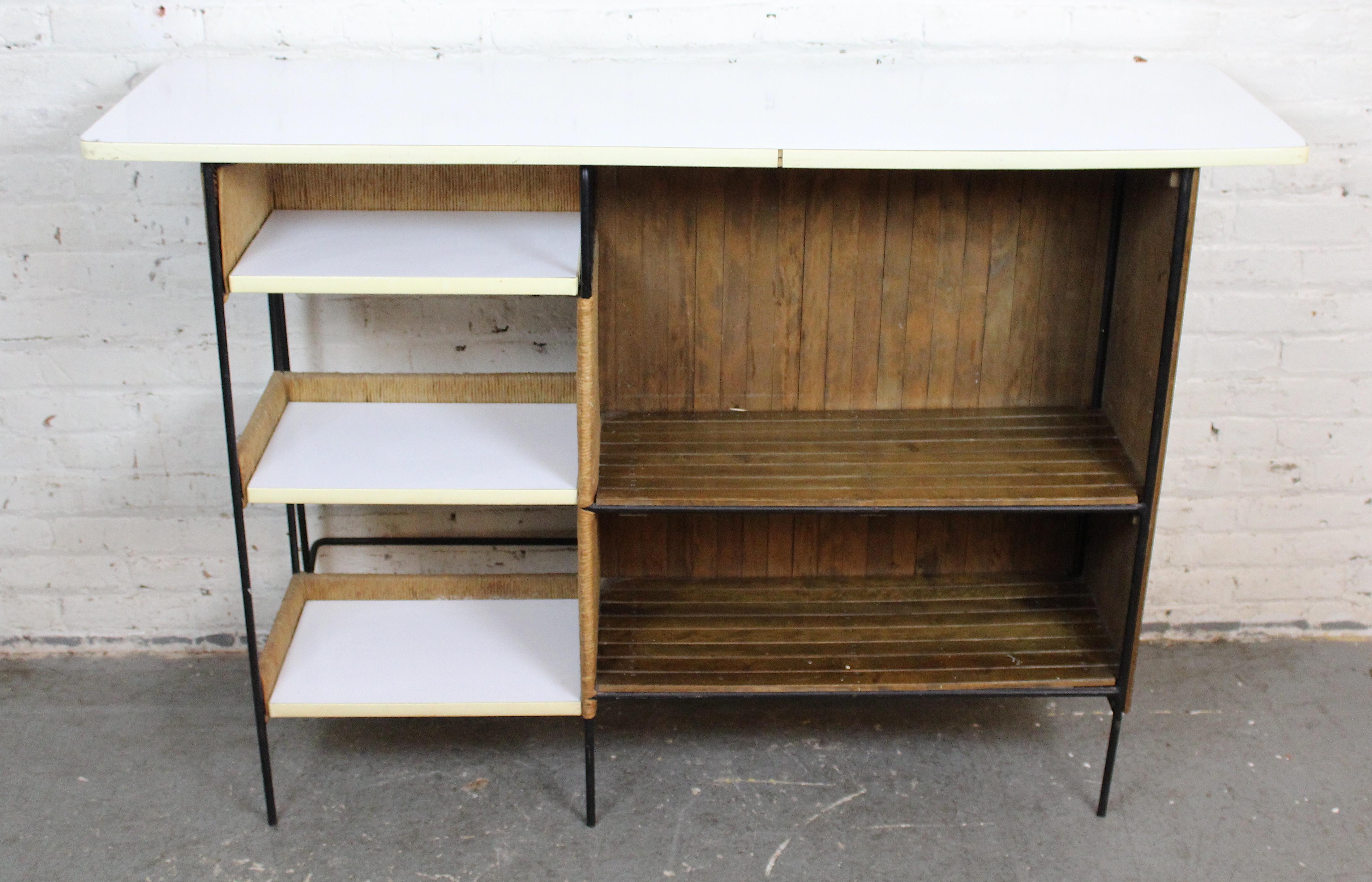 Bar sec emblématique de la modernité du milieu du siècle, conçu par Arthur Umanoff pour Raymor Furniture. Umanoff était l'un des principaux designers américains des années 1960, et Raymor Furniture était au sommet de l'importation. 
Le design de