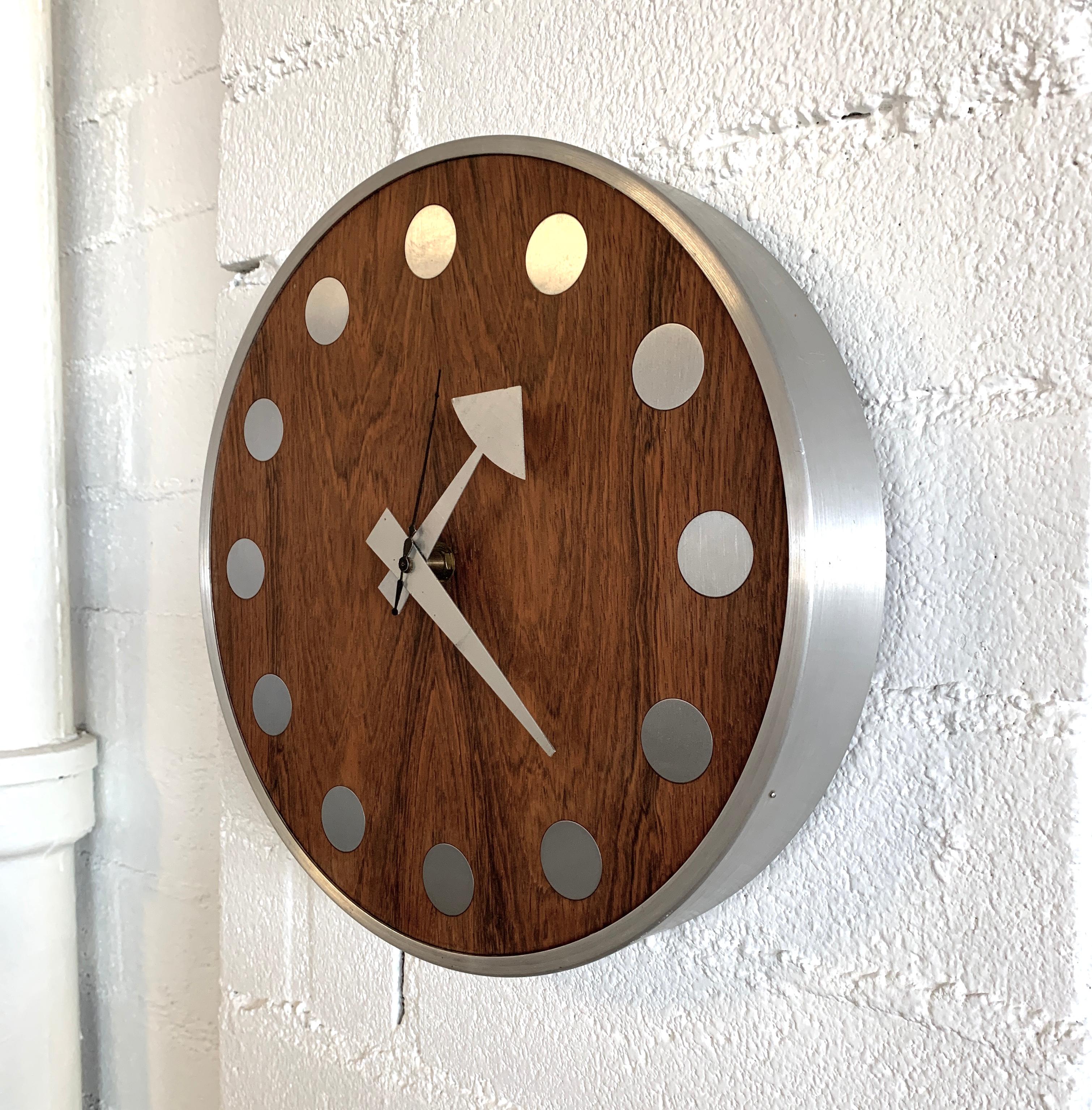 A beautiful rosewood wall clock designed by Arthur Umanoff for the Howard Miller Company in the early 1970s. This is model 7564 Meridian. It has a quartz movement. We put a new battery in and it works nicely. Aluminum shell and hands with a rosewood