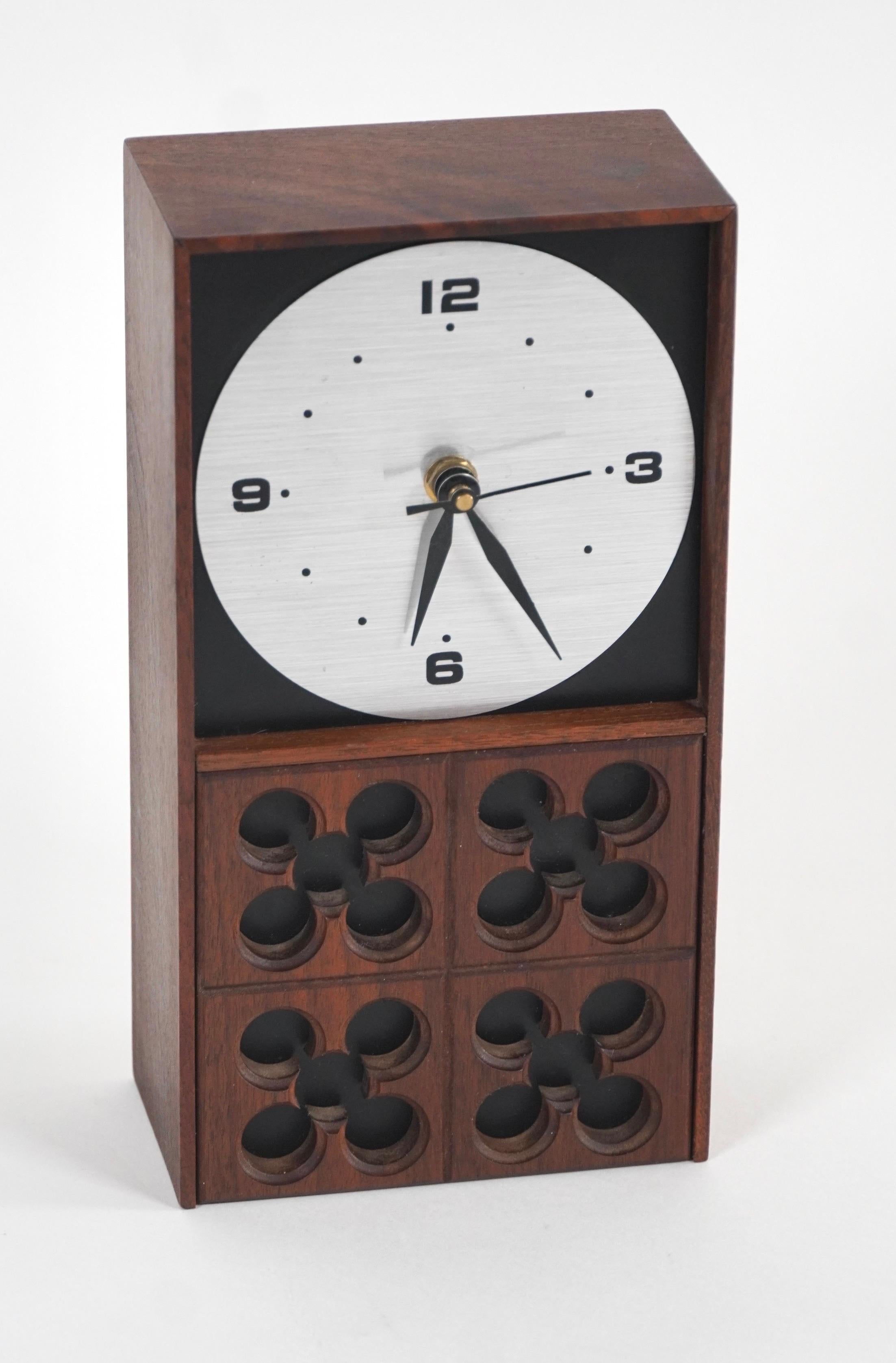 Desk clock by American industrial designer Arthur Umanoff (1923-1985) stylized walnut case with a aluminum face and black painted hands and numerals, this clock has hour, minute and second hands, it keeps accurate time with an battery operated