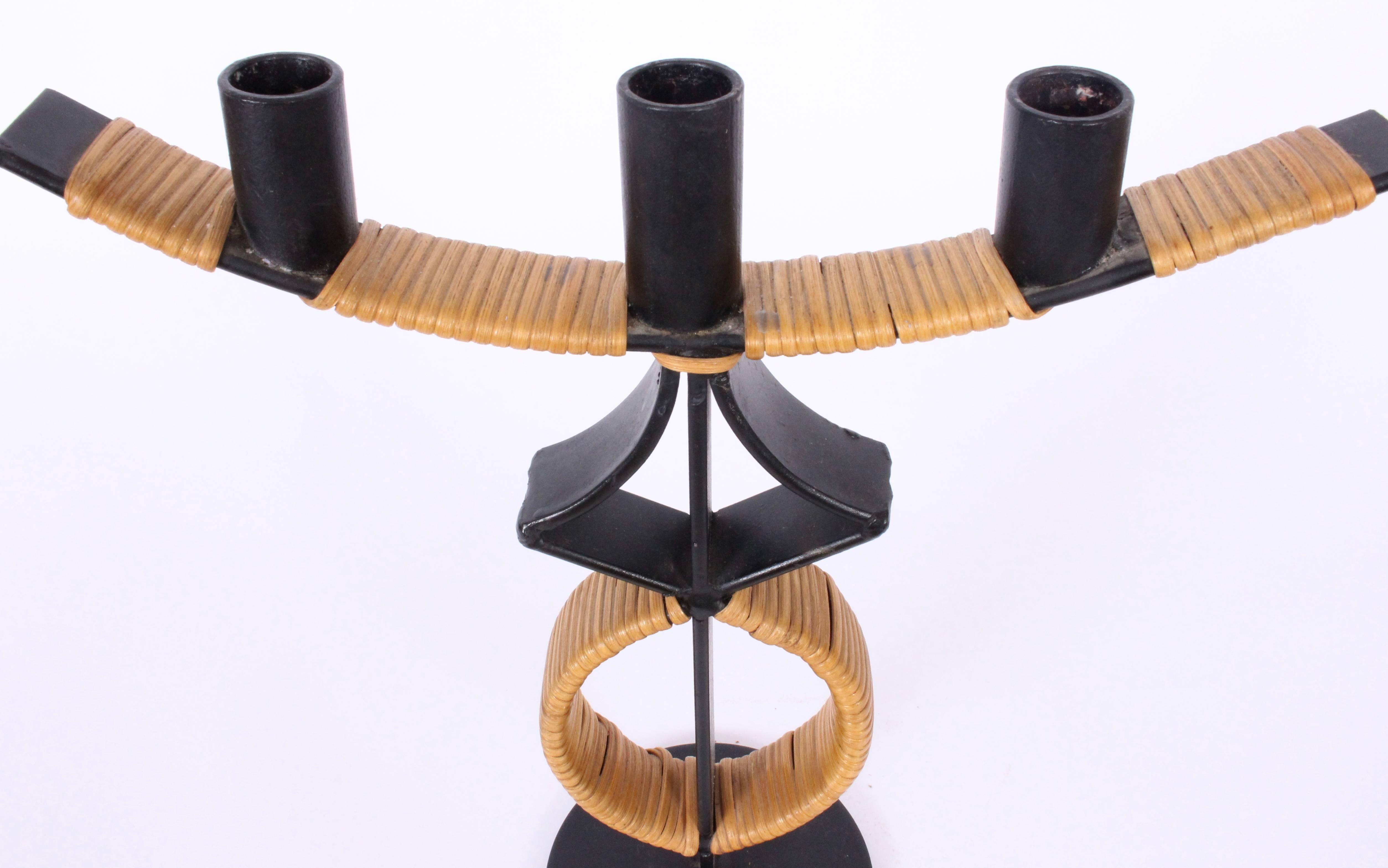 Arthur Umanoff for Raymor Black Wrought Iron & Wrapped Rattan Triple Candlestick, Candle Holder. Handcrafted Wrought Iron T form with natural Rattan detail. Utilizes three 1 inch candles. Sculptural. American Mid Century. Rarity. 