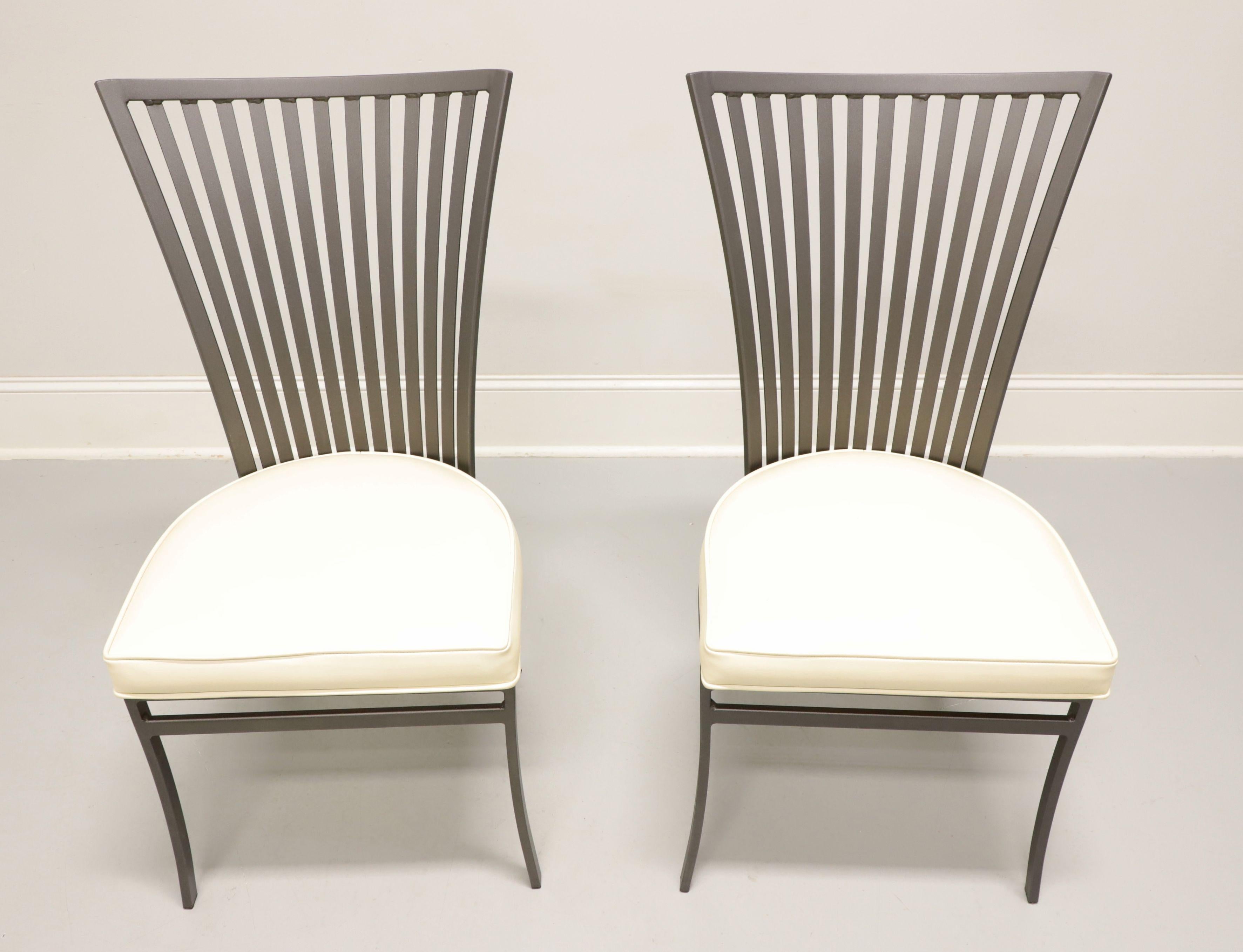 A pair of Mid 20th Century Modern style steel patio side chairs designed by Arthur Umanoff for Shaver-Howard. Steel metal frame, grey color finish, flared backrest with straight crestrail & spindles, white vinyl upholstered seat, open apron, and