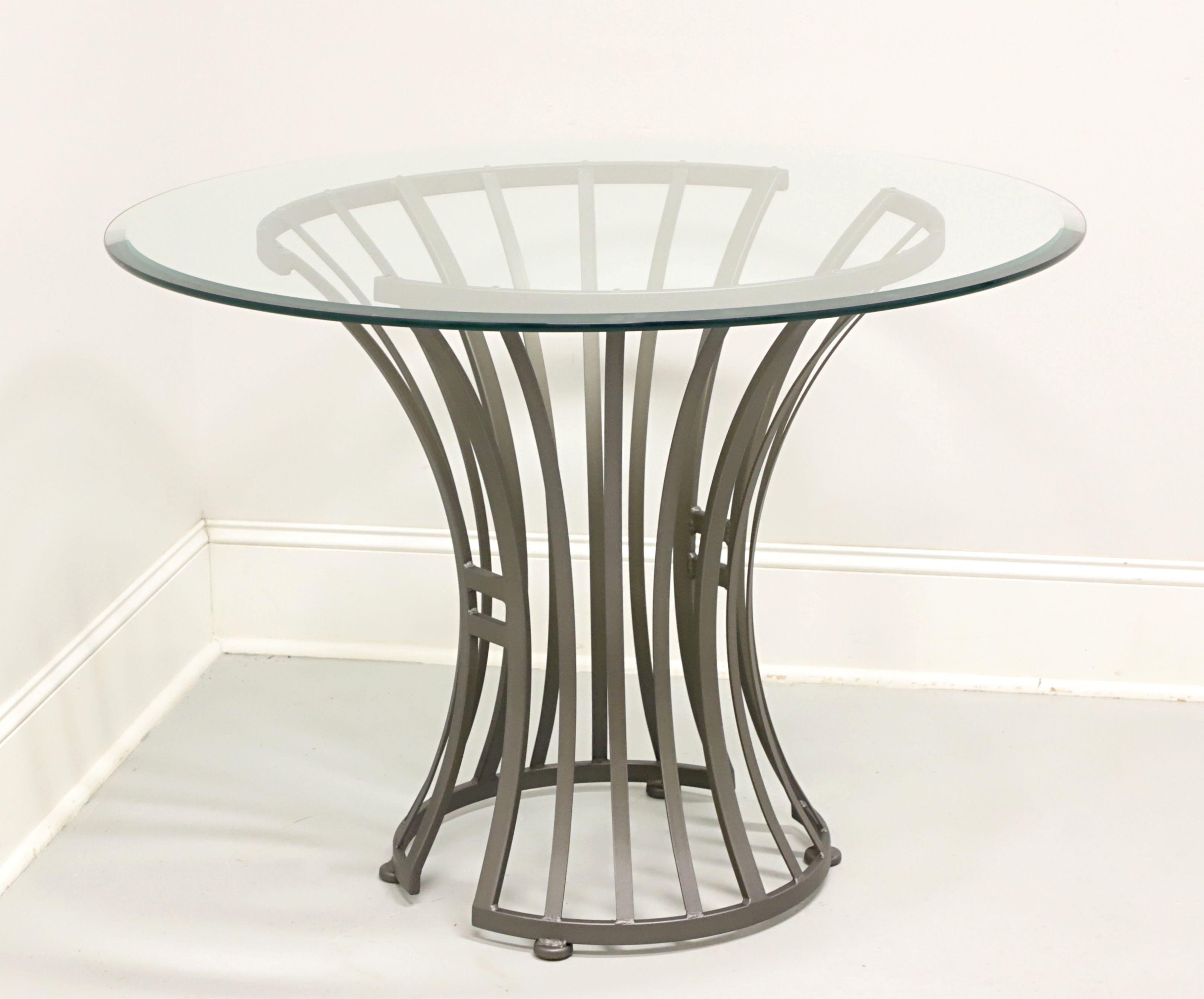 A Mid 20th Century Modern style round patio dining table designed by Arthur Umanoff for Shaver-Howard. Steel metal frame, round bevel edge glass top, grey color finish, flared wheat sheaf shaped pedestal base with open design, and cap feet. Made in