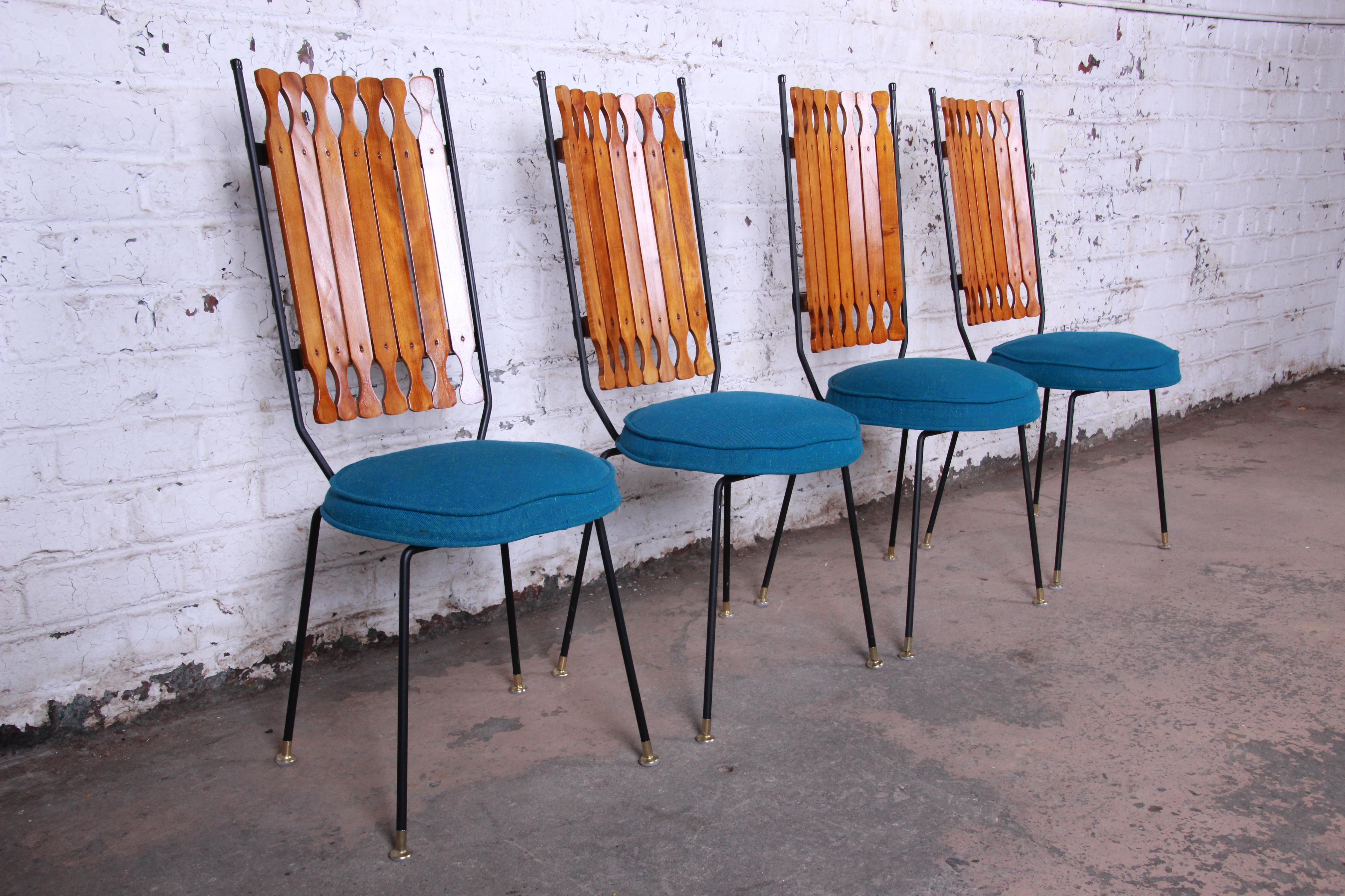 Offering a rare and unique set of four Mid-Century Modern iron, wood, and upholstered high back dining chairs designed by Arthur Umanoff for Shaver-Howard. The chairs feature sturdy black iron frames, unique slatted wood seat backs, and newer teal