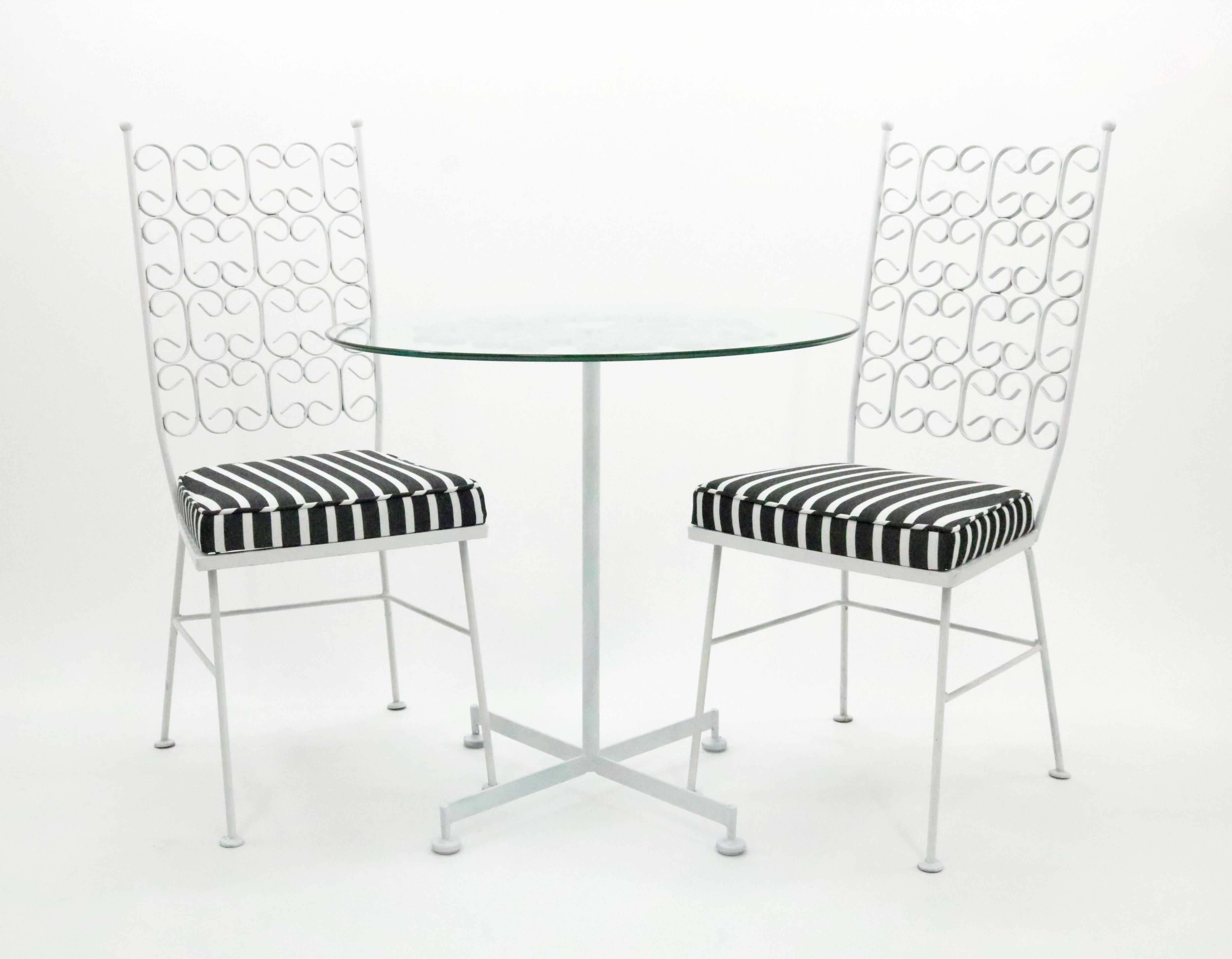 An iconic bistro set by Arthur Umanoff from his Granada Collection for the Boyeur Scott Furniture Co. USA, 1960s.

Wrought iron frames with new black & white café stripe indoor/outdoor seat upholstery and cushion foam - and a new glass table