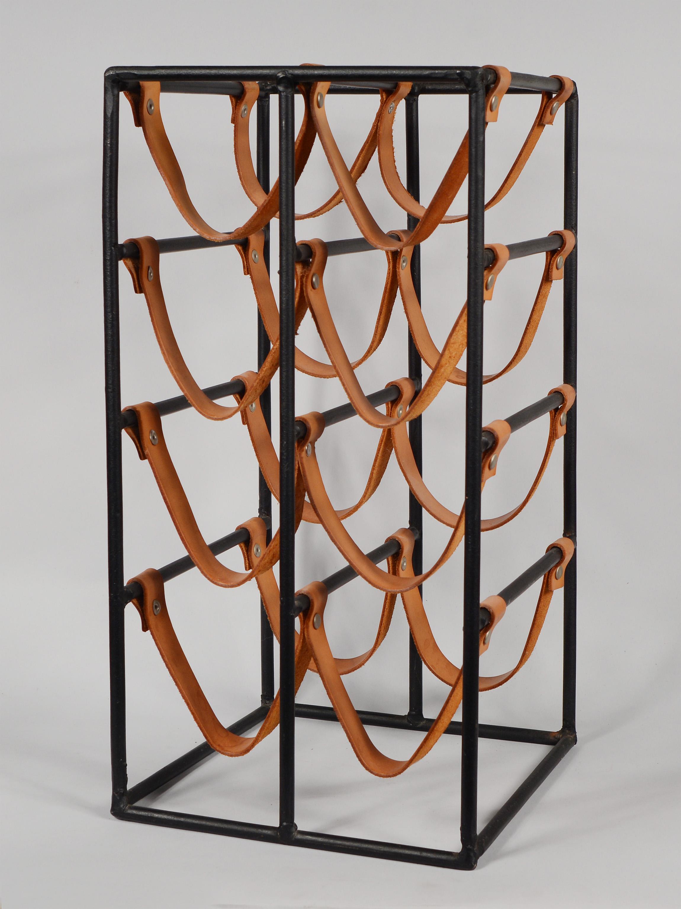 Iron and leather wine rack designed by Arthur Umanoff for Shaver Howard. This rack holds eight bottles. A couple of the leather rivets are not original.