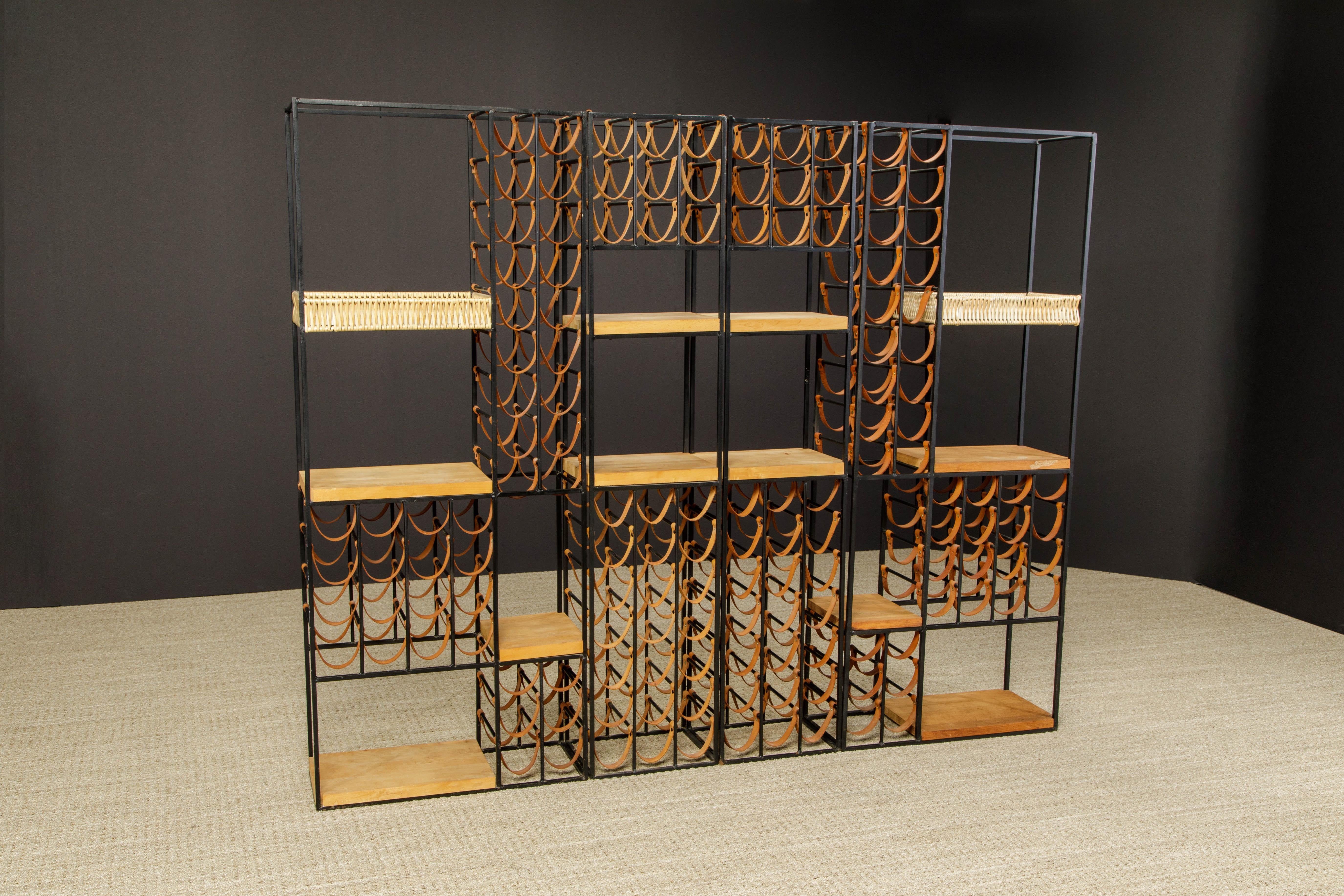 The ultimate entertaining piece, this Arthur Umanoff four section wine rack system and room divider which also incorporates an artful array of one hundred forty leather wine bottle holders, two wicker baskets, ten butcher block wooden shelves, and