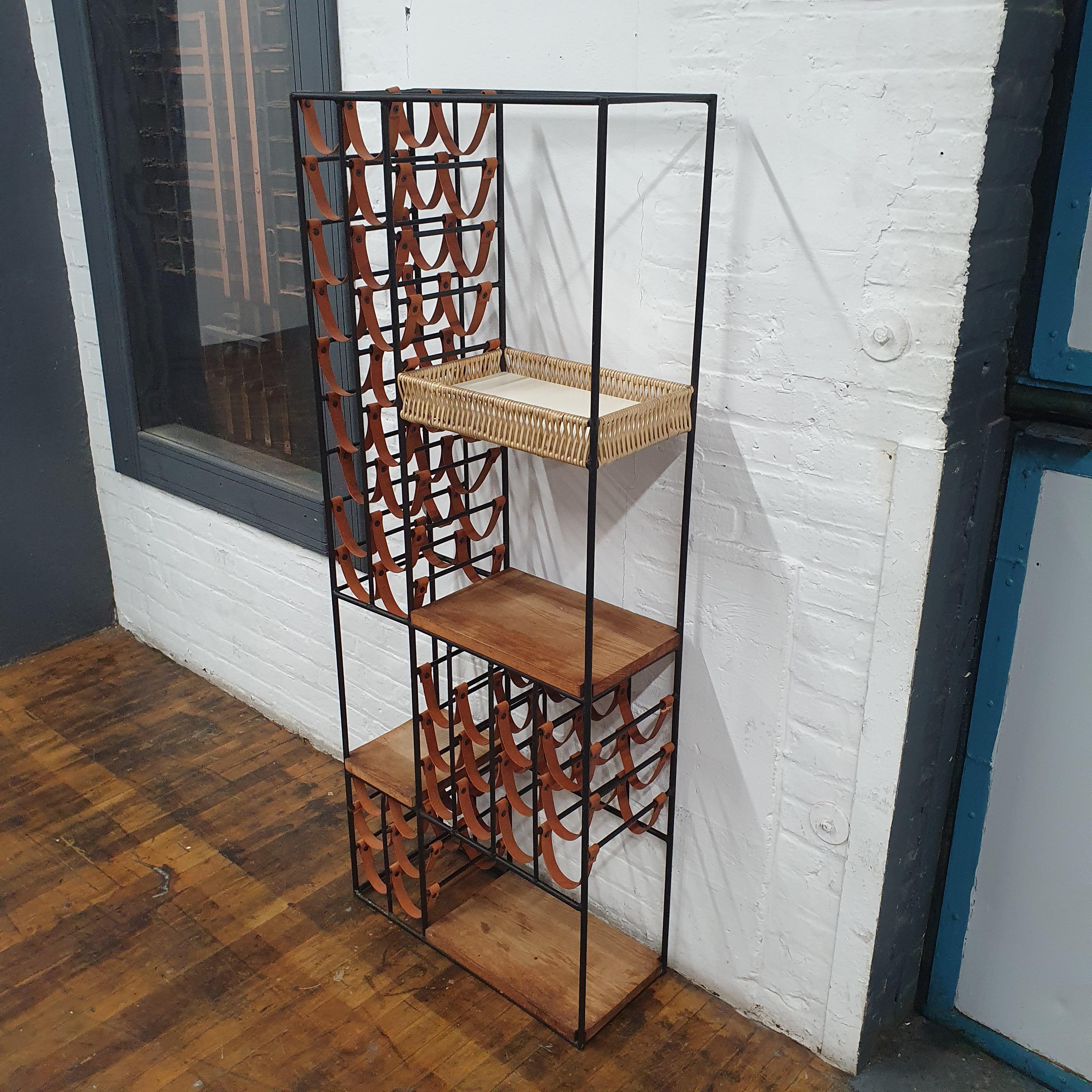Arthur Umanoff for Shaver Howard Iron and leather wine rack. the leather straps can hold 40 bottles. has three wood butcher block shelves and a wicker basket shelf. can serve as a room divider as well. its finished on all sides.