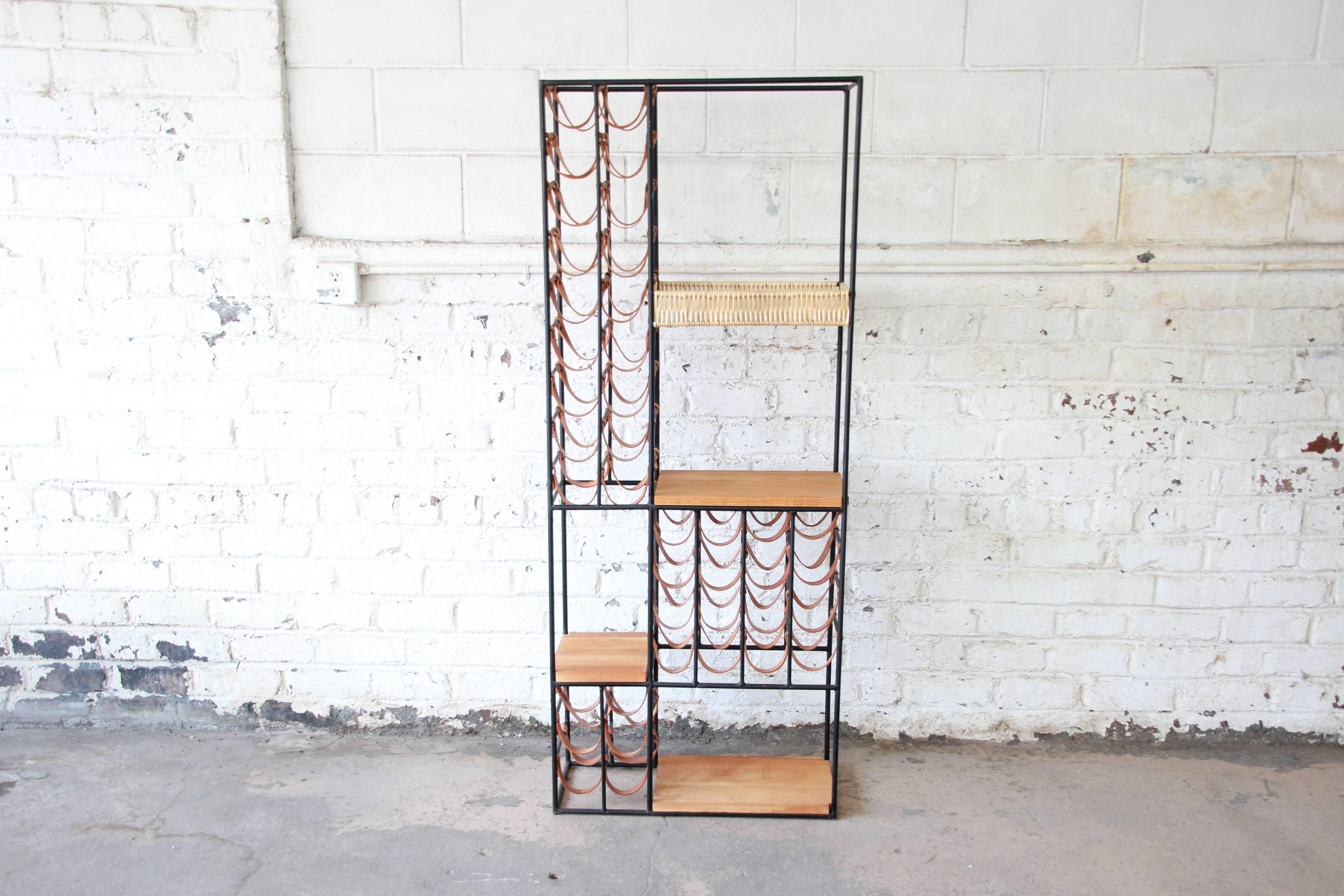 An exceptional and rare 40-bottle wine rack designed in 1954 by Arthur Umanoff for Shaver Howard. The rack features an iron frame with rows of leather slings for holding wine bottles. It has three butcher-block shelves of solid wood, as well as a