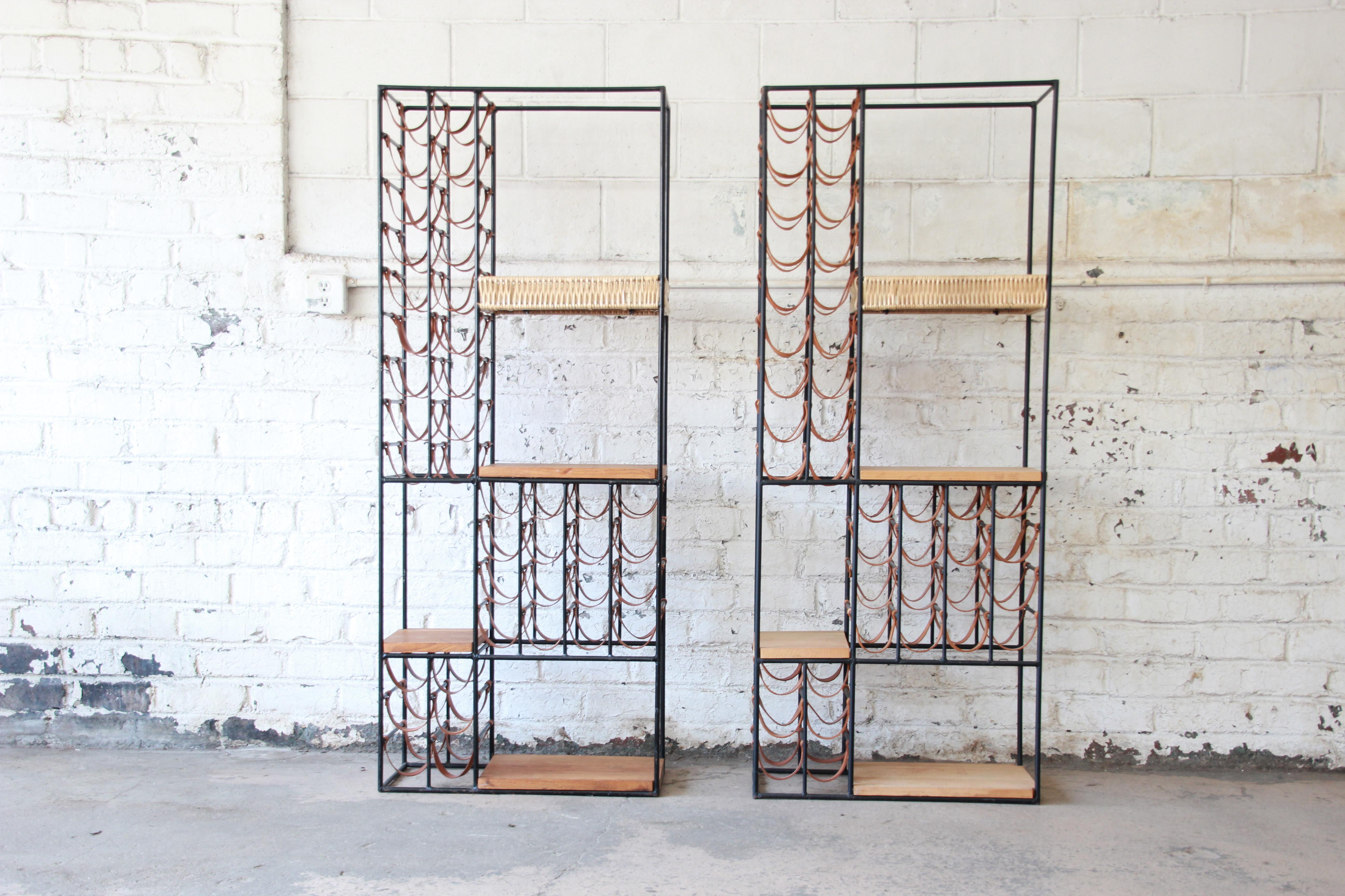 An exceptional and rare pair of 40-bottle wine racks designed in 1954 by Arthur Umanoff for Shaver Howard. The racks feature iron frames with rows of leather slings for holding wine bottles. They have three butcher-block shelves of solid wood, as