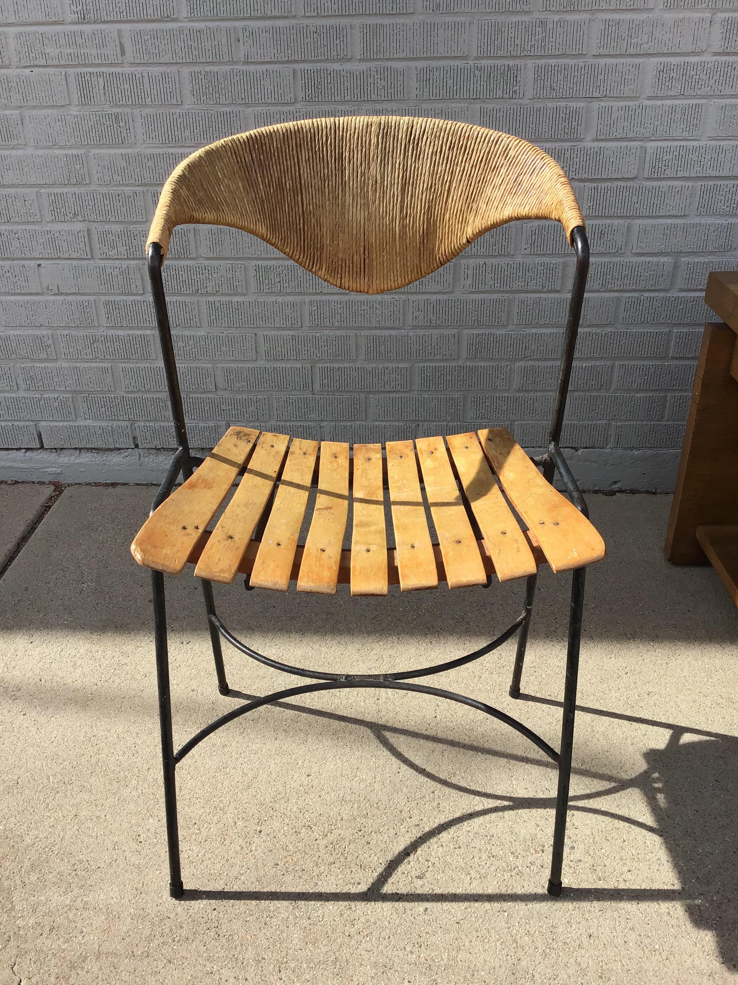 Sedia scultorea di Arthur Umanoff con schienale in giunco, seduta in legno a doghe e gambe in ferro. Splendido da ogni angolazione!

Misure: Altezza 32,5