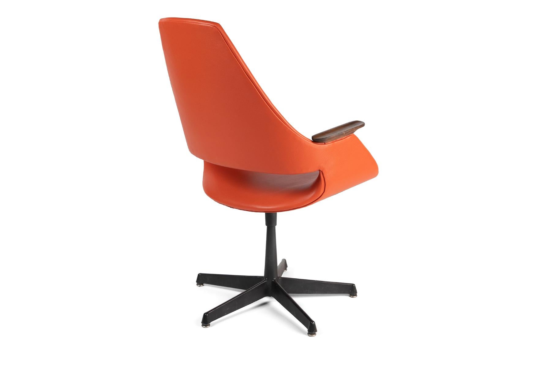 Arthur Umanoff orange leather, steel and walnut chair, circa late 1960s. This example has been newly upholstered in a persimmon orange Spinneybeck leather and the walnut arms refinished. Metal base retains patina. Arm height is 25
