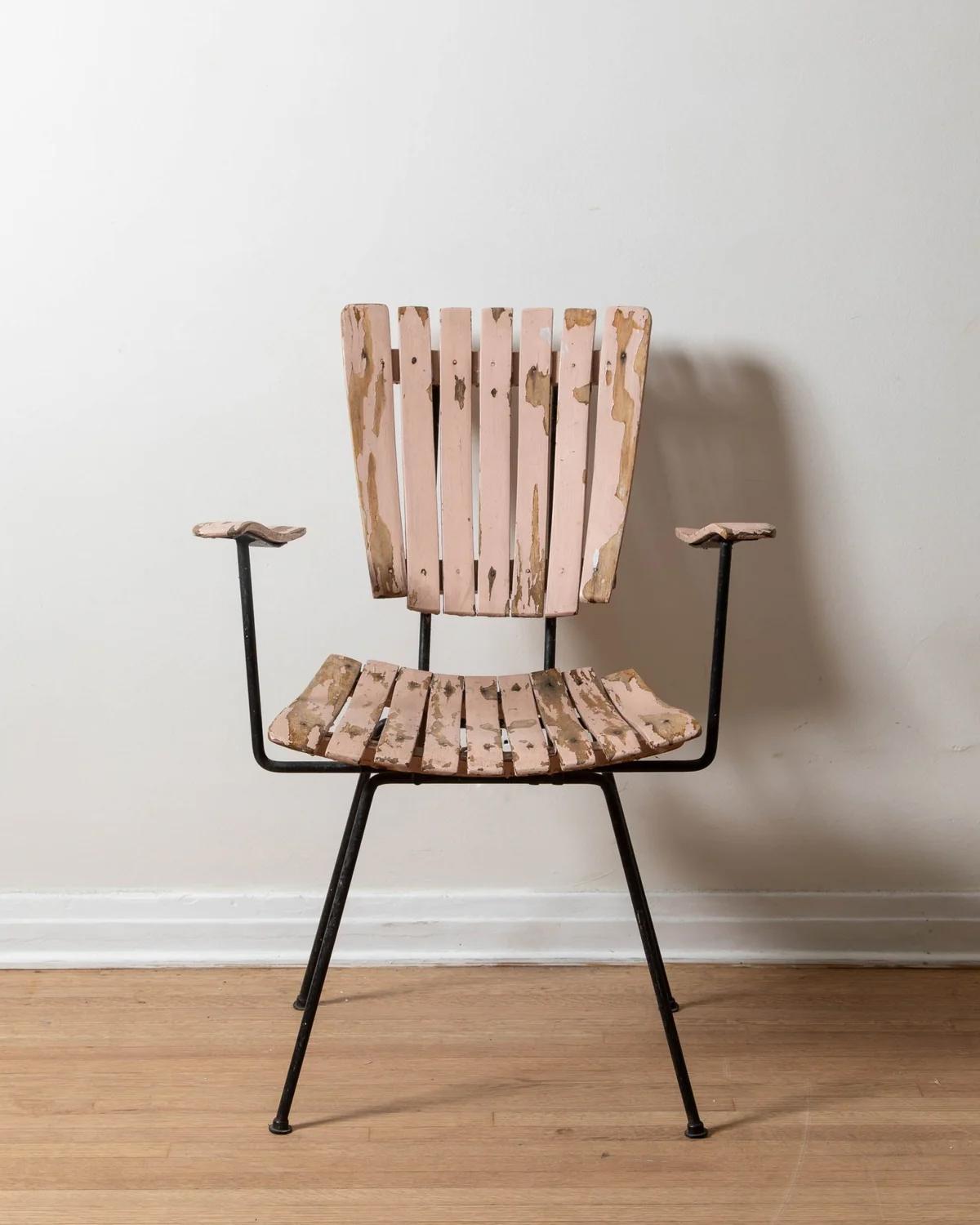 Disegnata da Arthur Umanoff, questa rara sedia a doghe si discosta dalle versioni in teak senza braccioli più comuni, offrendo una rivisitazione unica del suo iconico design di metà secolo. Questo esemplare è stato dipinto in un rosa tenue e