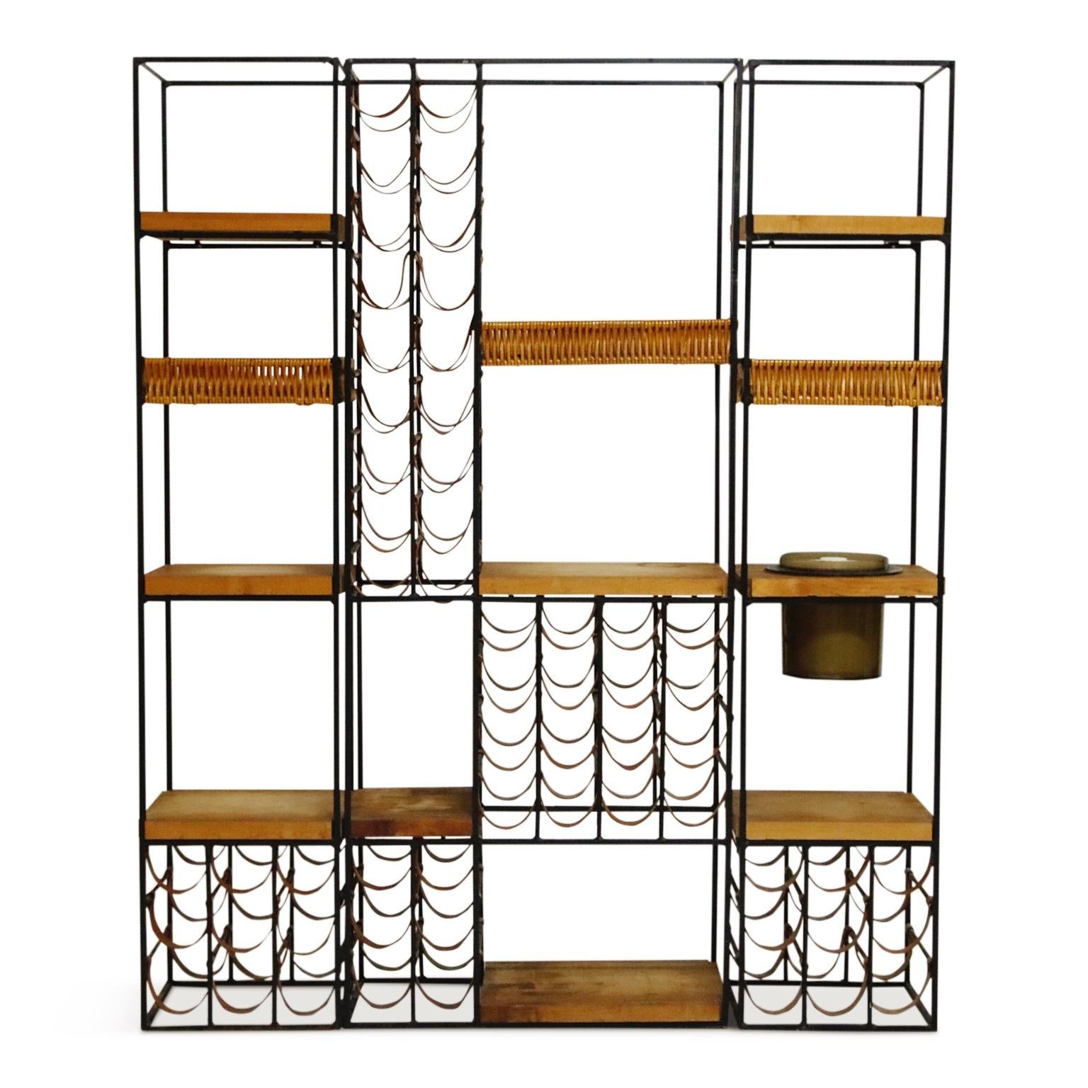 The ultimate entertaining piece, this Arthur Umanoff three (3) section wine rack system and room divider which also incorporates an artful array of fifty-eight (58) leather wine bottle holders, three (3) wicker baskets, eight (8) butcher block