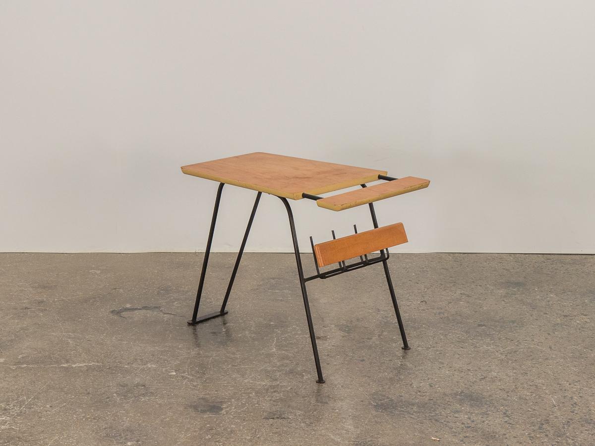 Side table with magazine rack designed in the likeness Arthur Umanoff. Wedge-shaped solid birch table surface floats on an iron base with rack for reading material underneath. A flexible, space-saving solution for the living room. Surface has a warm