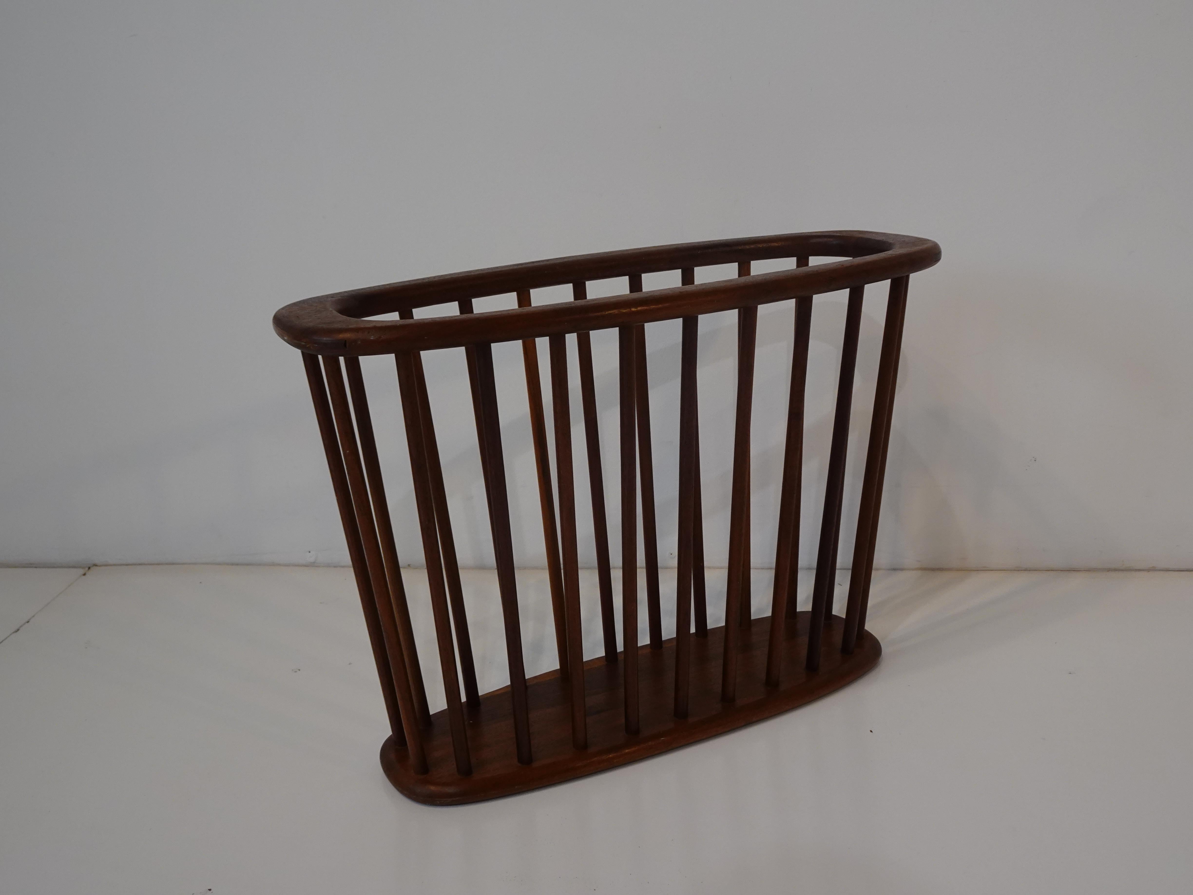 A mid century walnut magazine rack with dowel construction designed by Arthur Umanoff, very well crafted so it will hold your books or light reading materials.