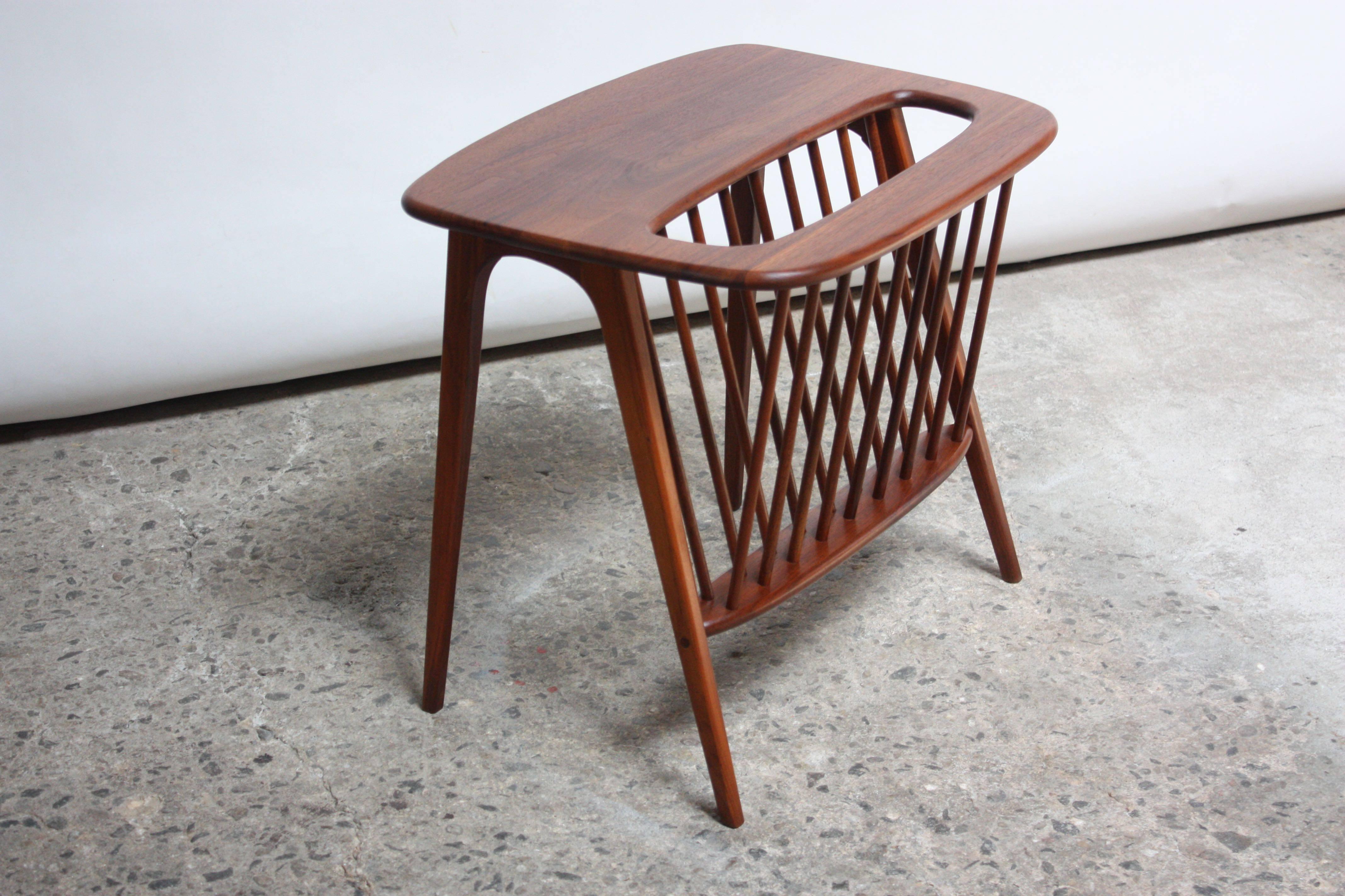 Sculptural Arthur Umanoff solid walnut end table with spindle-constructed magazine rack. Graceful piece with exceptional lines in beautiful, refinished condition.
 