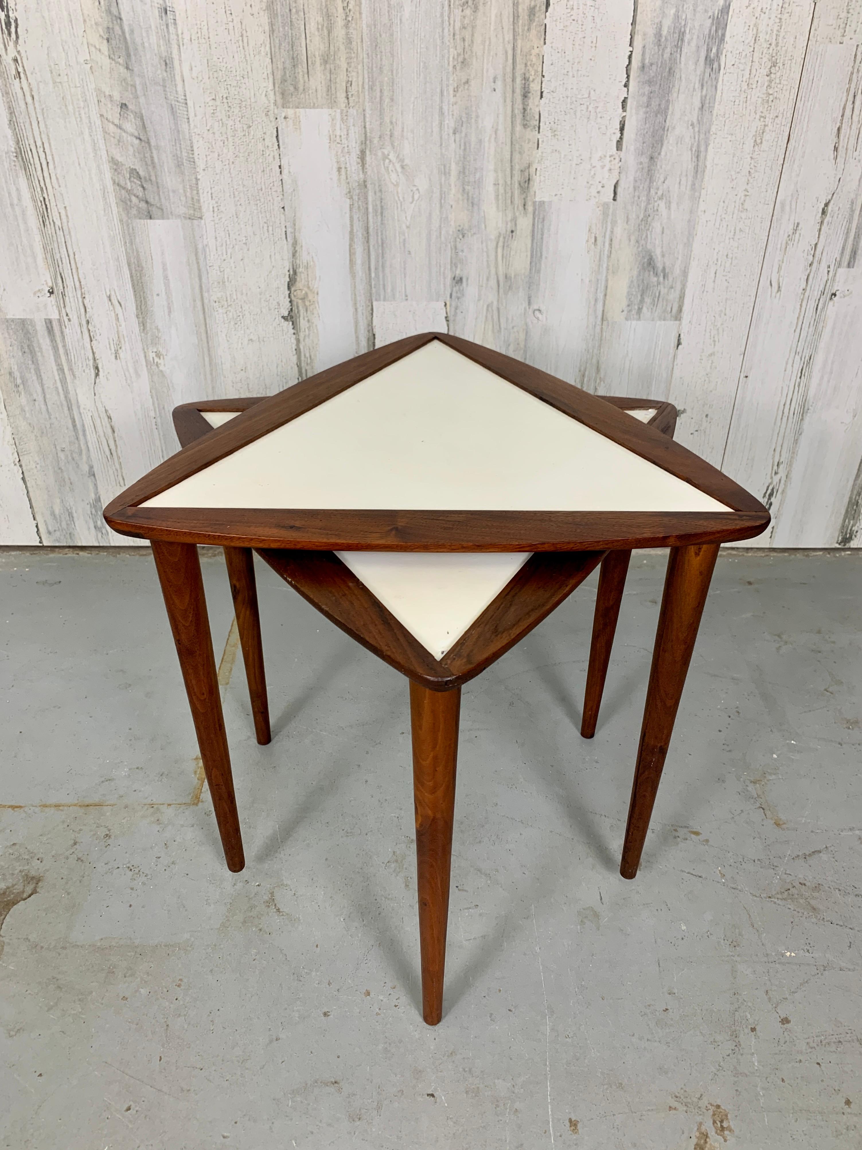 A pair of stacking drinks tables in triangle shaped design.
Walnut with white masonite tops.
