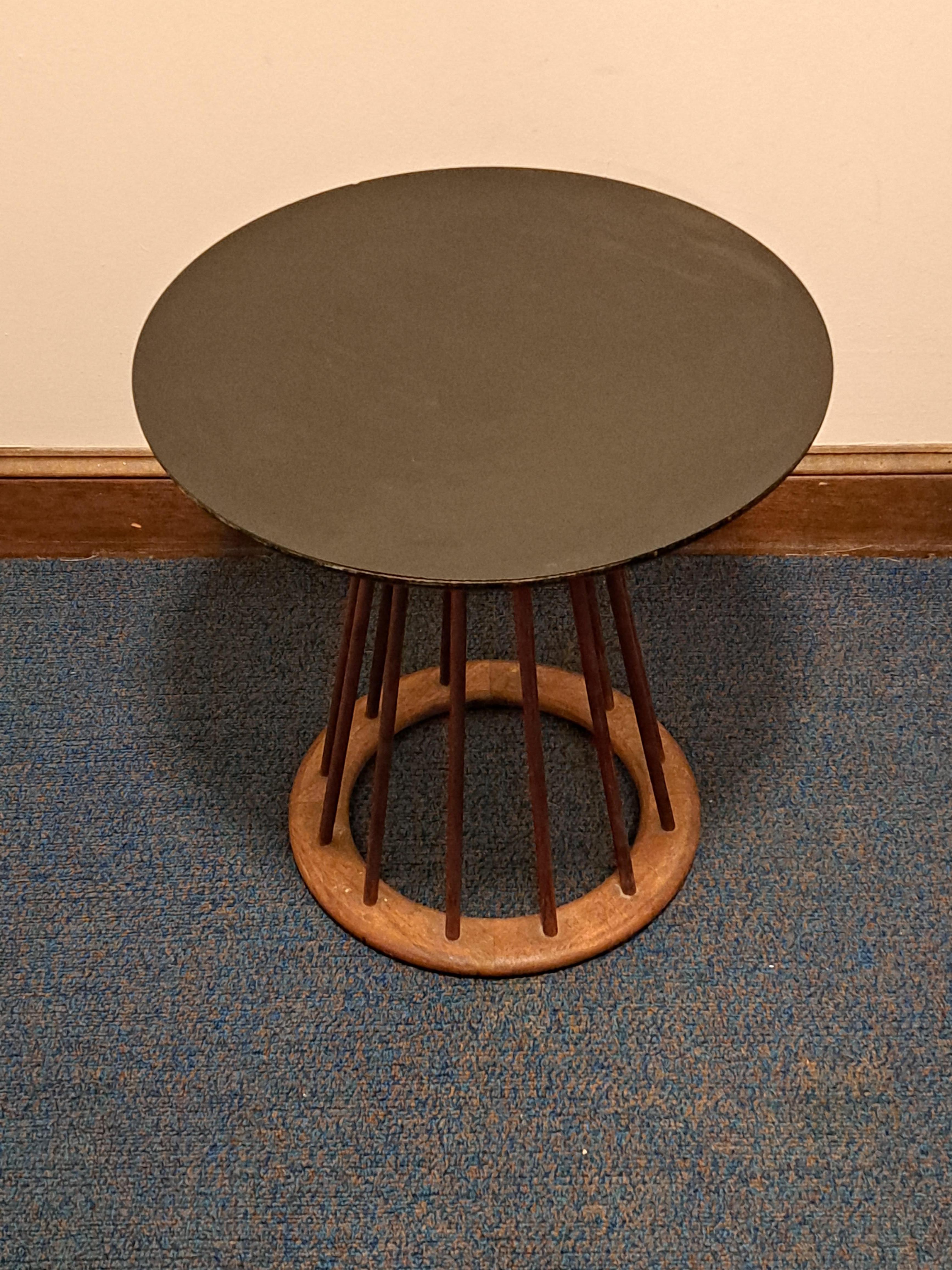Side/end table with spindles and black laminated top. Table is designed by Arthur Umanoff of walnut wood. Table has circular base with narrow wooden spindles that meet at the table top.