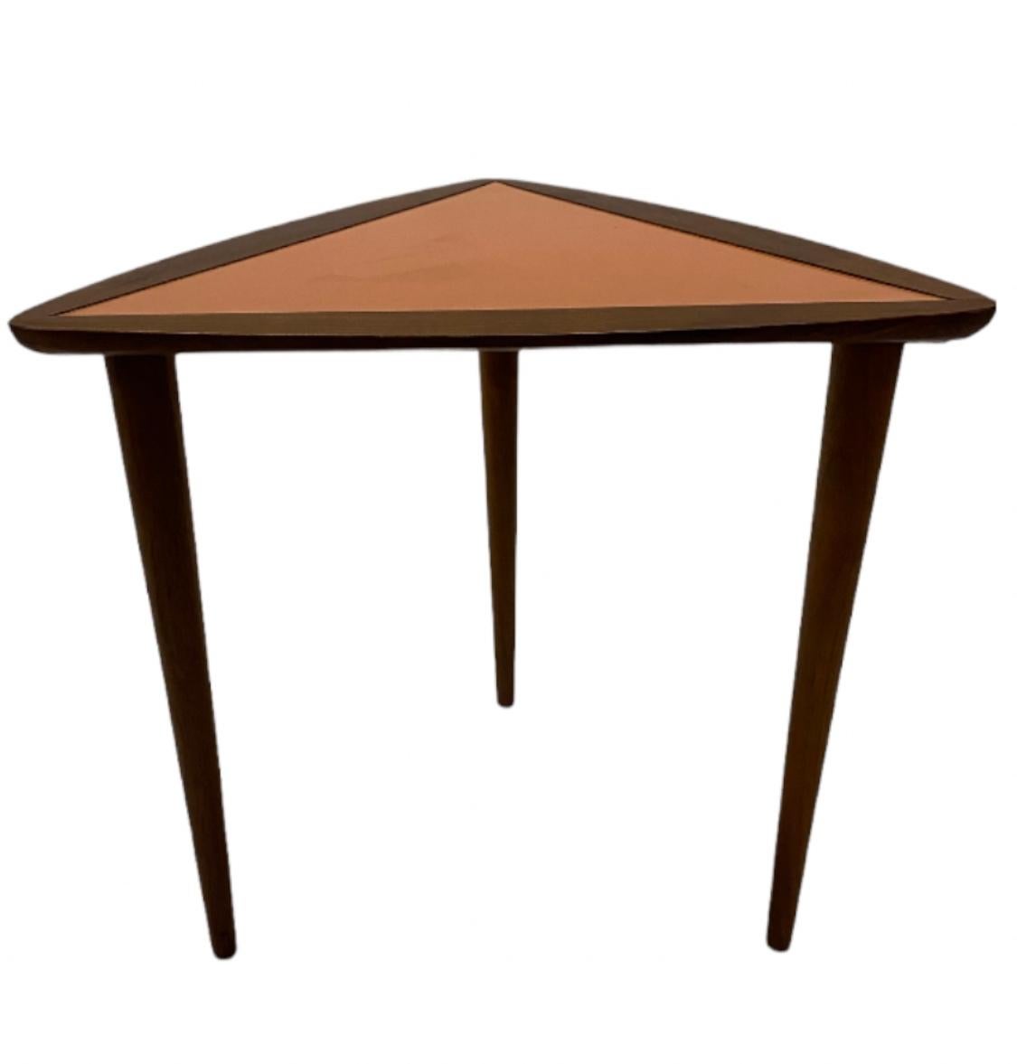 Arthur Umanoff triangular side table in walnut with original orange surface. Solid turned walnut legs can unscrew for easy storage and shipment. In good condition with great color and wood tones.