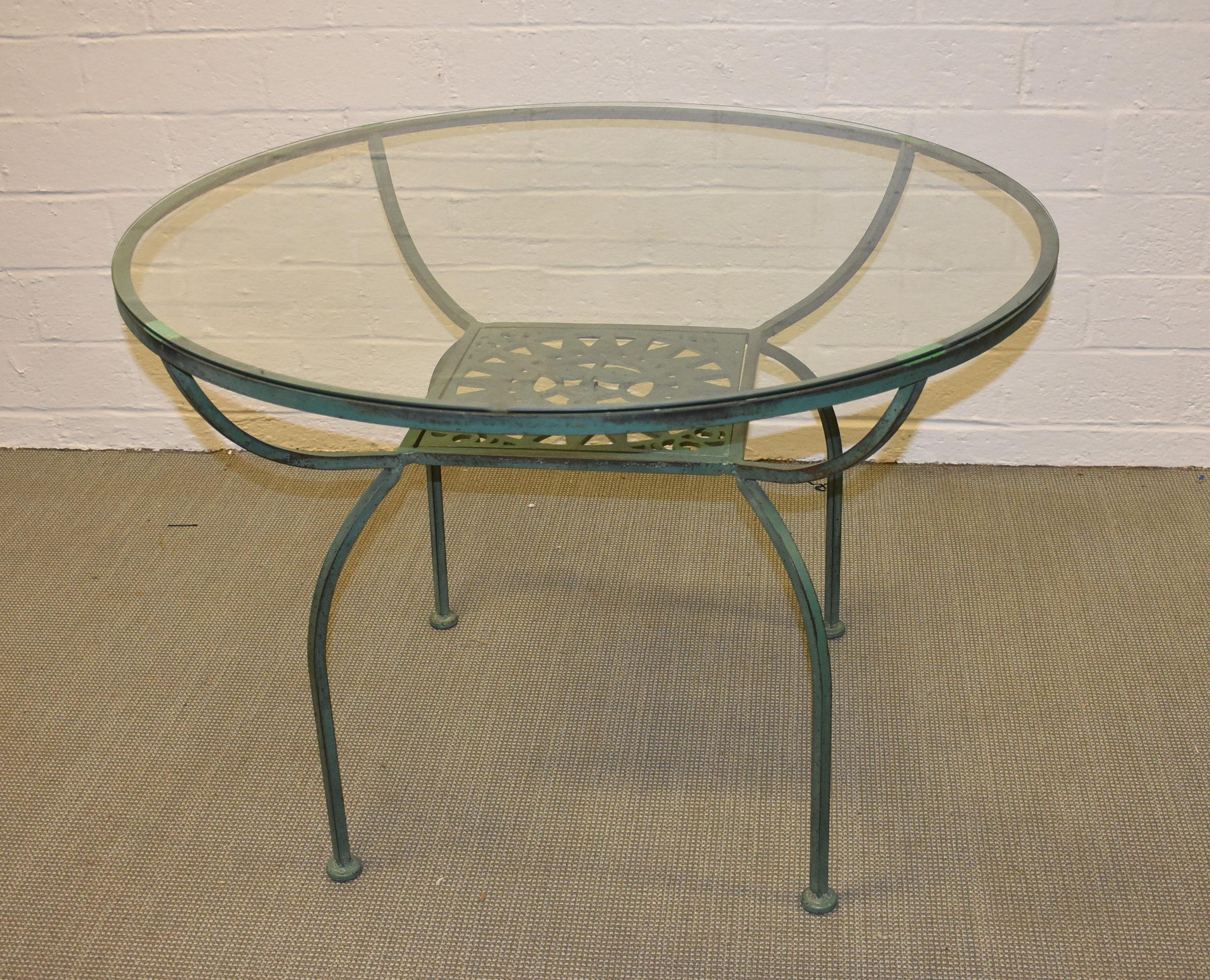 Attractive green wrought iron patio set by Arthur Umanoff. Chairs and table feature the Mayan sun design and curved frames. Set includes a 42