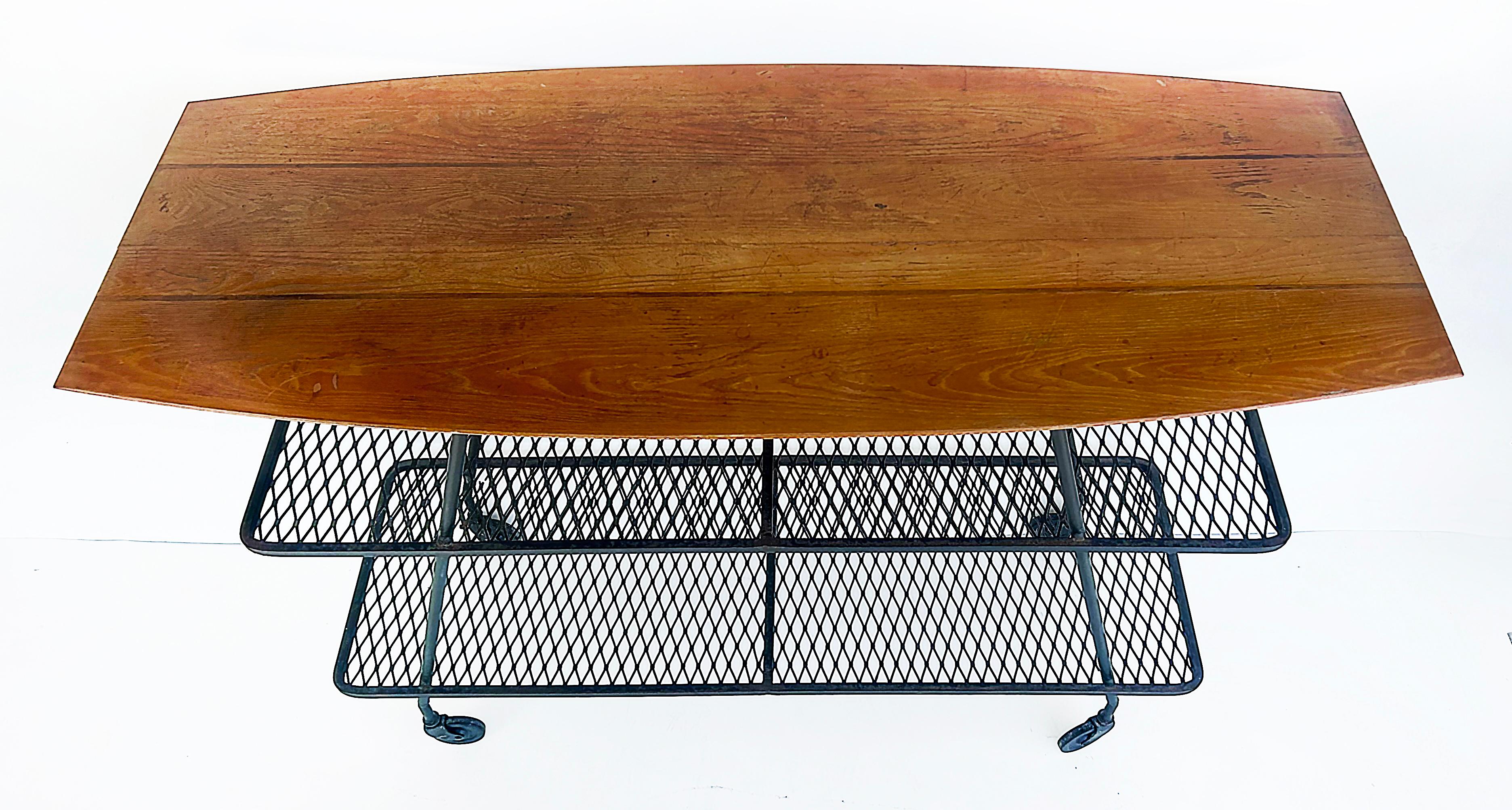 Arthur Umanoff Wrought Iron Rolling Bar Cart, Surfboard Wood Top

Offered for sale is an Arthur Umanoff mid-century modern wrought iron sculptural rolling bar cart with surfboard wood top and iron shelves below.  This wonderful designed bar cart