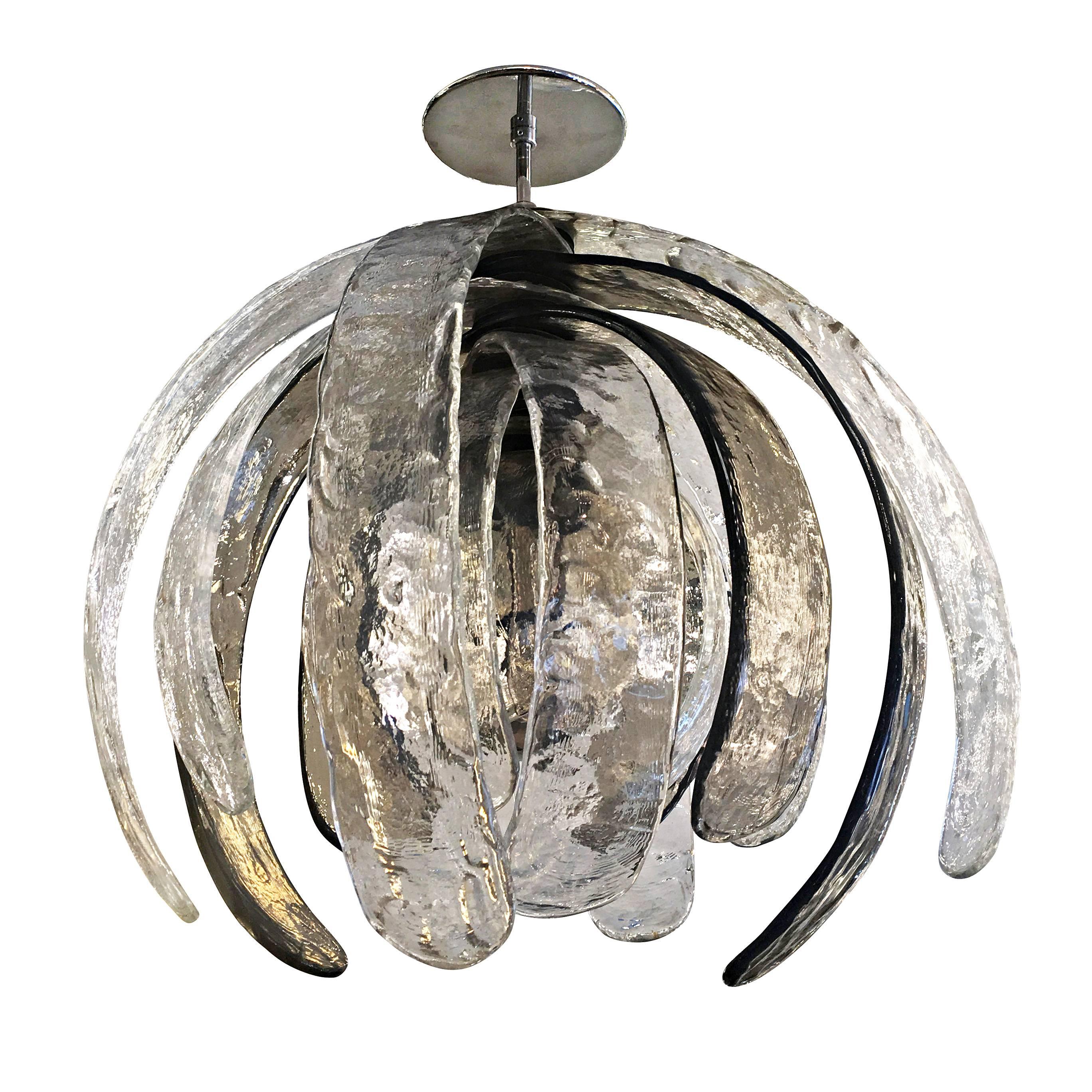 Sculptural Murano glass chandelier designed by Carlo Nason for Mazzega in the 1960s. Its composed of eleven textured petal shaped glasses that can rotate around the center stem. Four of the glasses are a dark gray and seven are clear. Holds one
